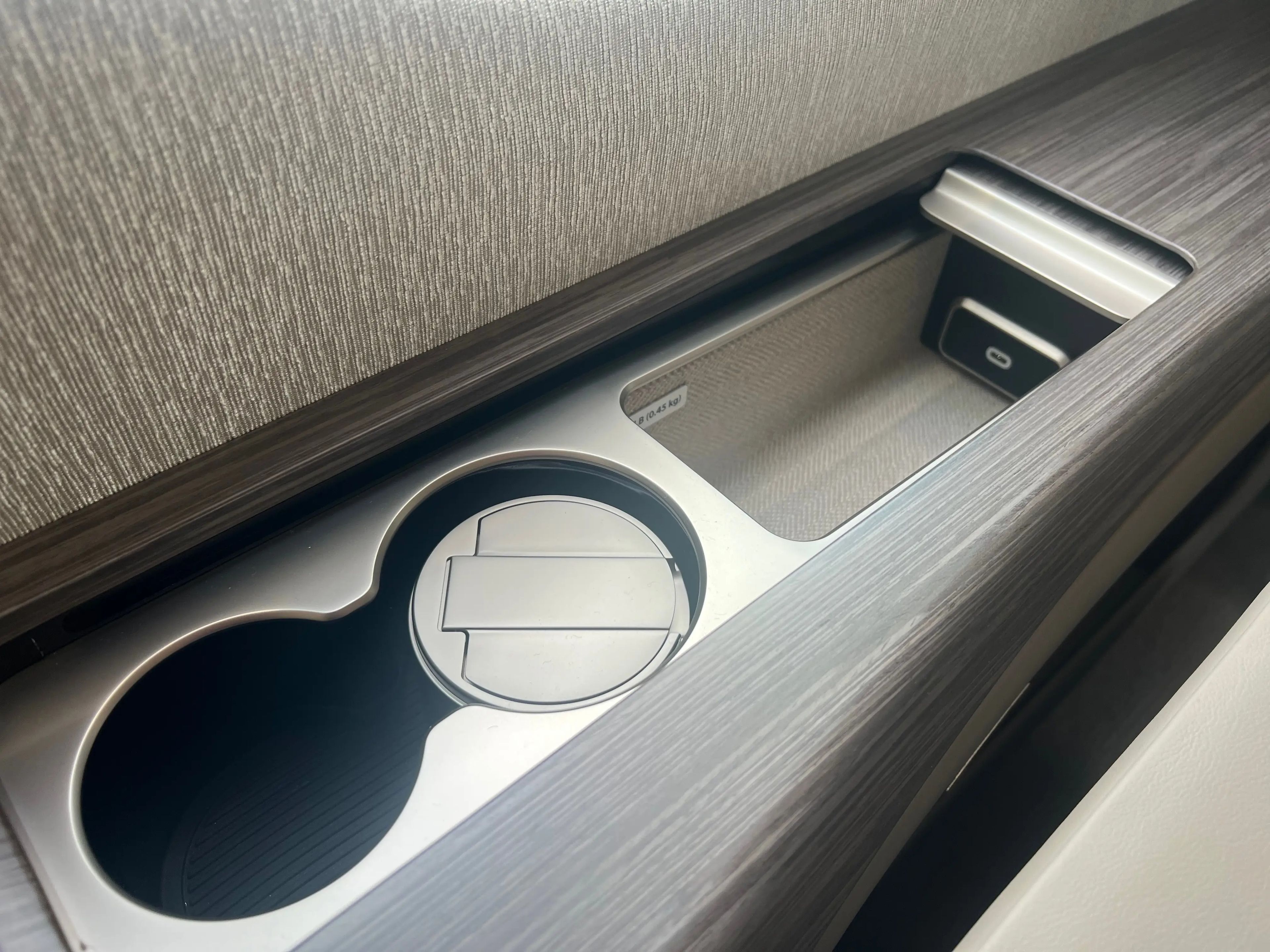 The cupholders and the charging port under sliding compartments.