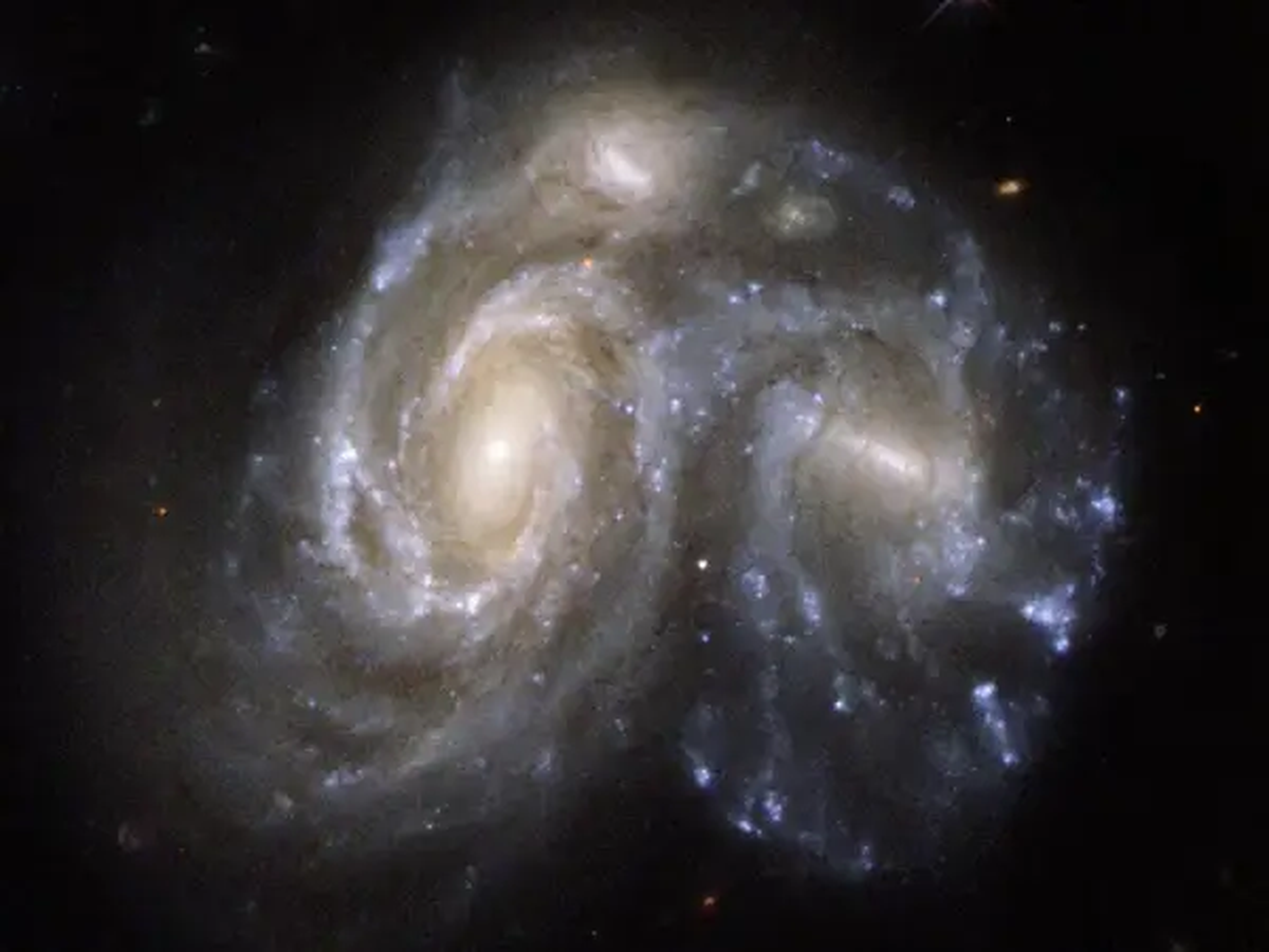 Dos galaxias con forma de espiral colisionando en una imagen captada por el telescopio espacial Hubble.
