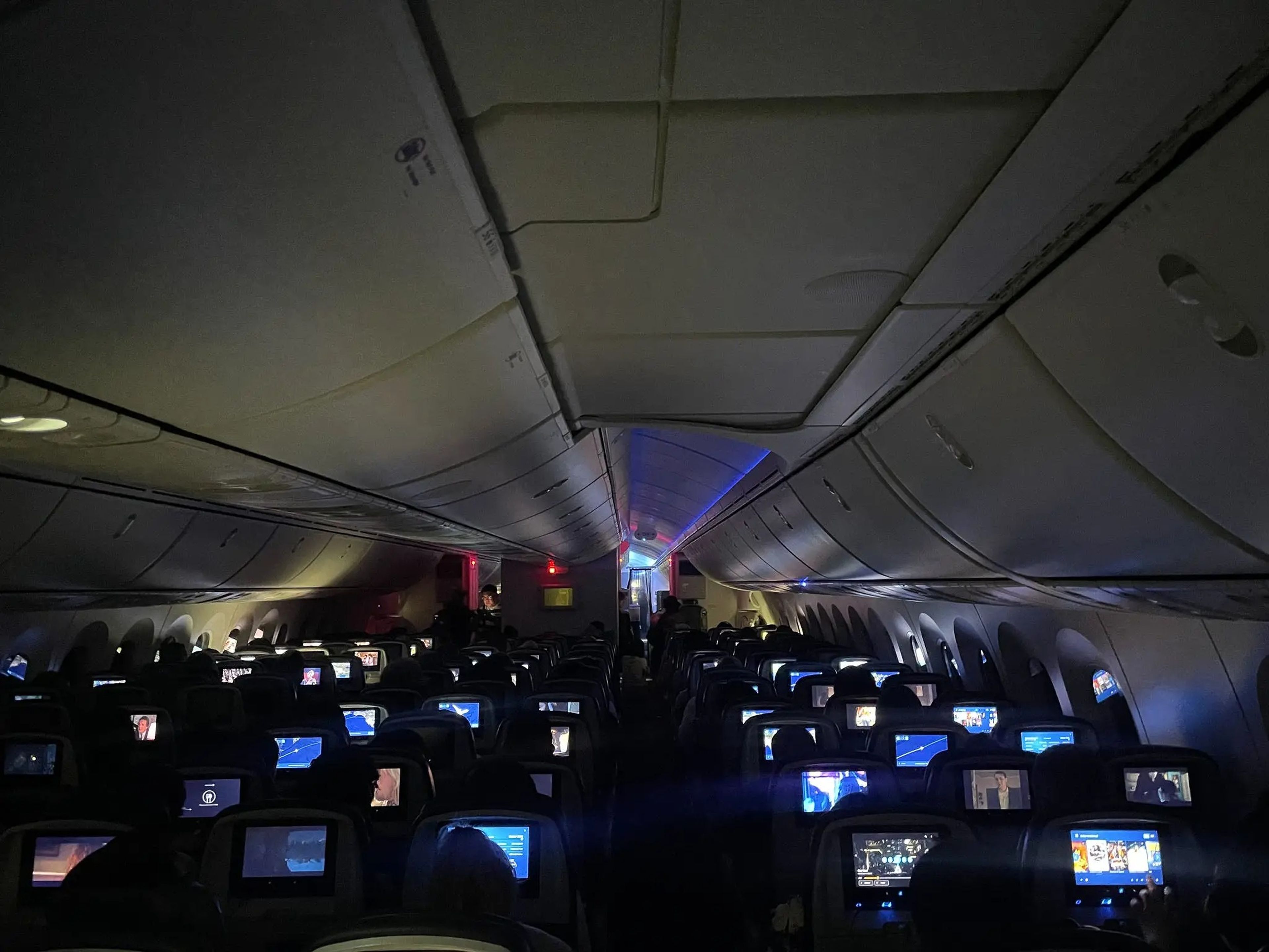 The interior of the plane's cabin with all the lights off.