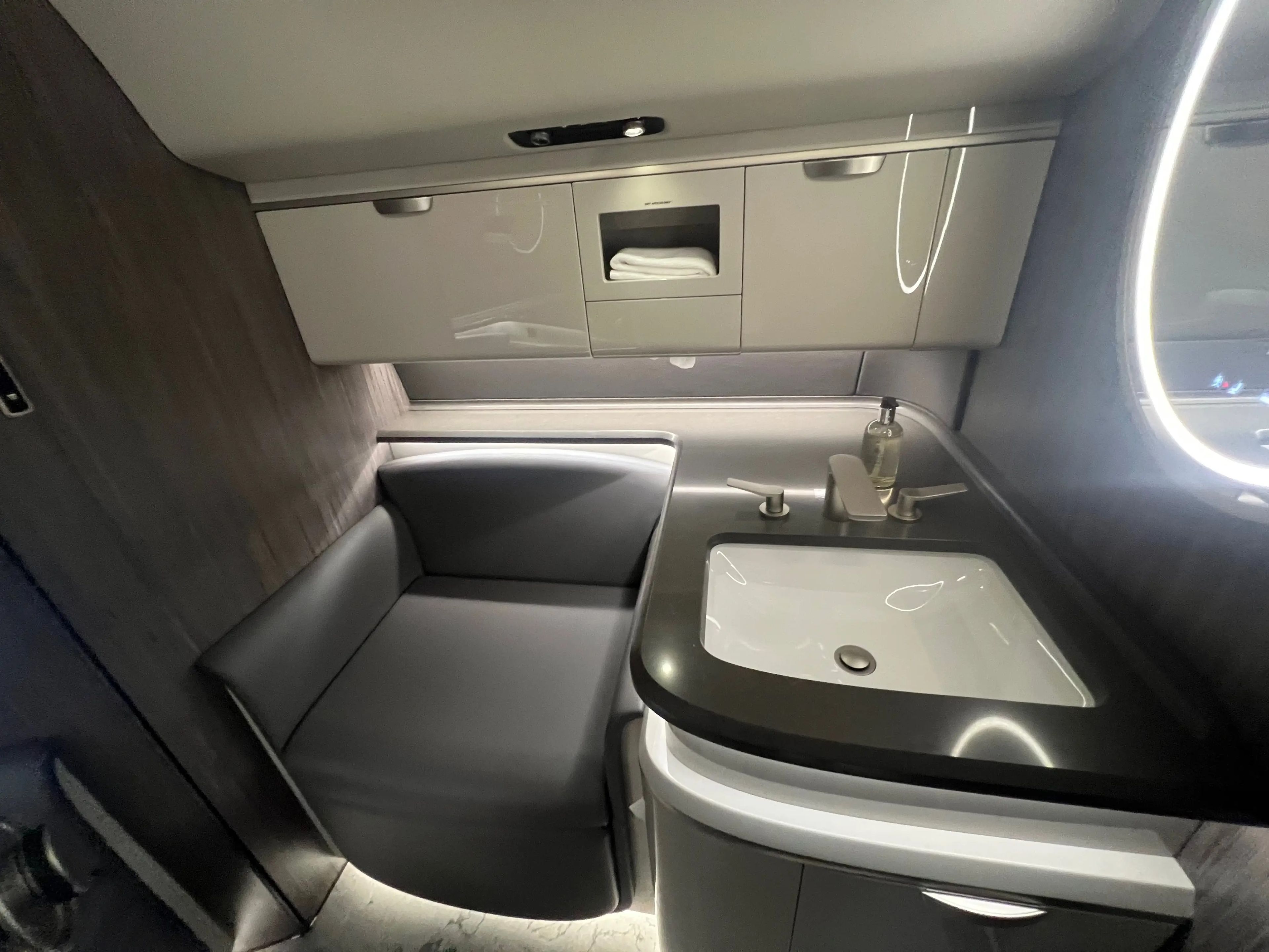 The lavatory with the toilet seat down to create a regular seat.