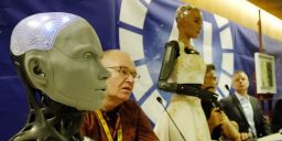 El robot humanoide Ameca (en primer plano), junto a Will Jackson (primero por la izquierda), CEO y fundador del fabricante británico Engineered Arts. 