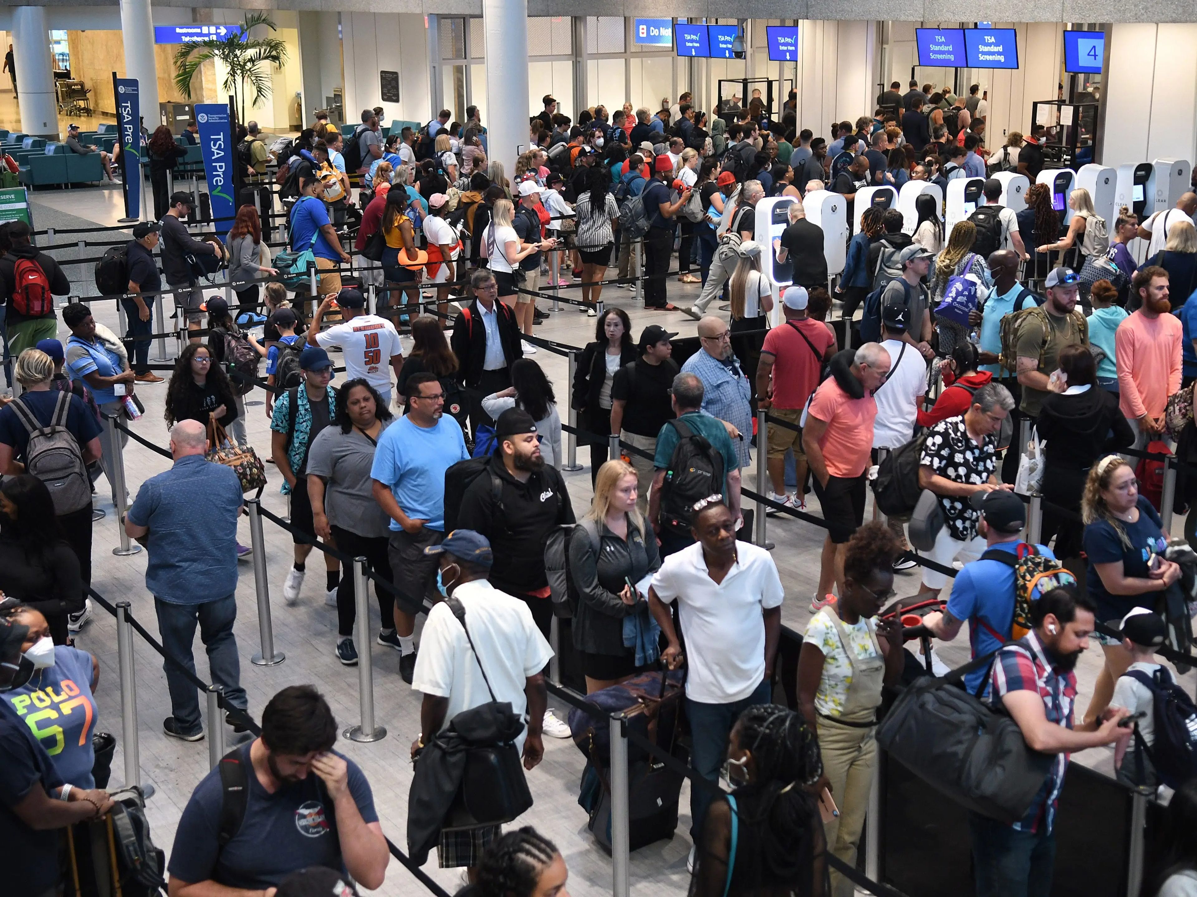 A long line of travelers make their way through a TSA screening line at Orlando International Airport ahead of the July 4 holiday.