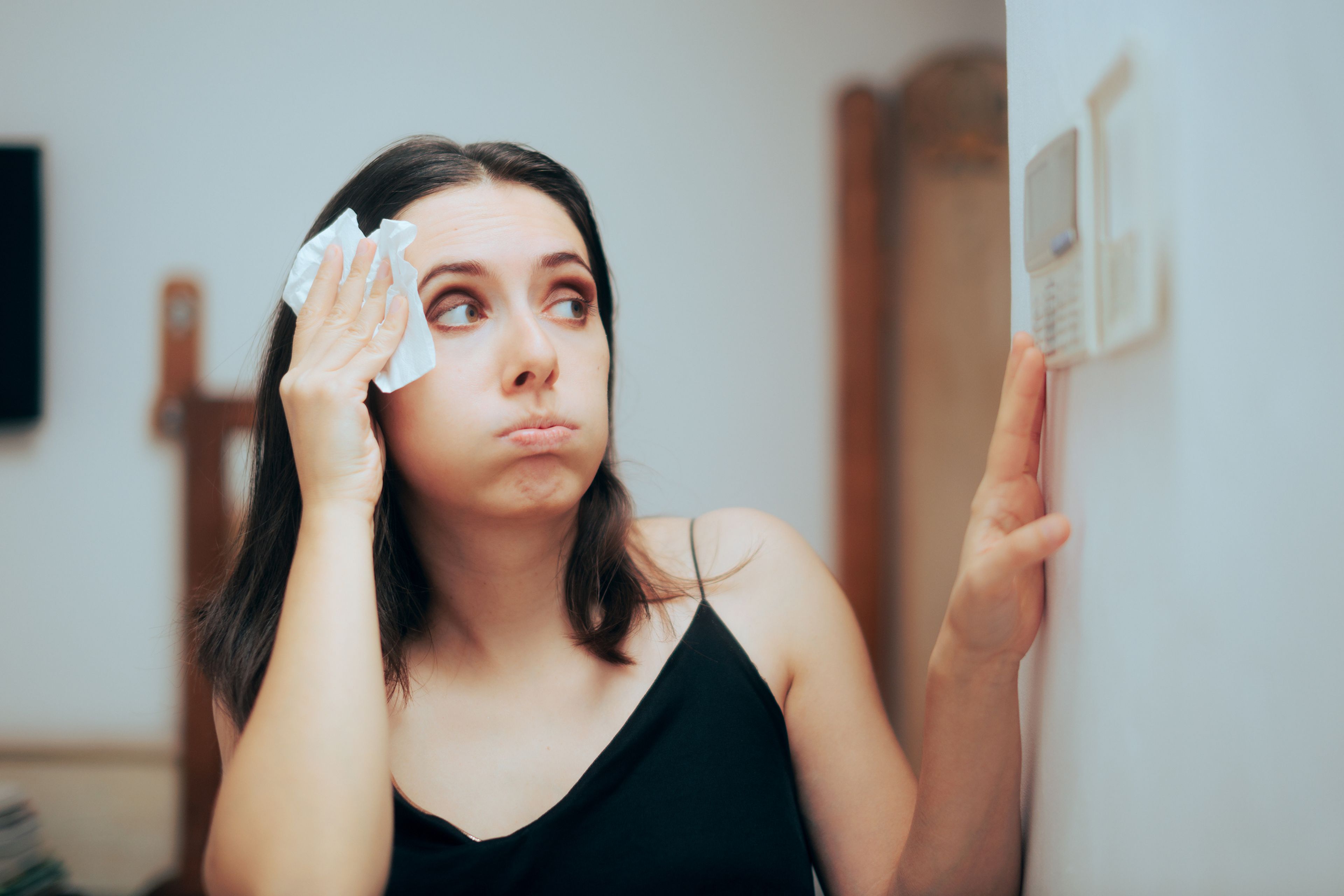 Una mujer enciende el aire acondicionado.