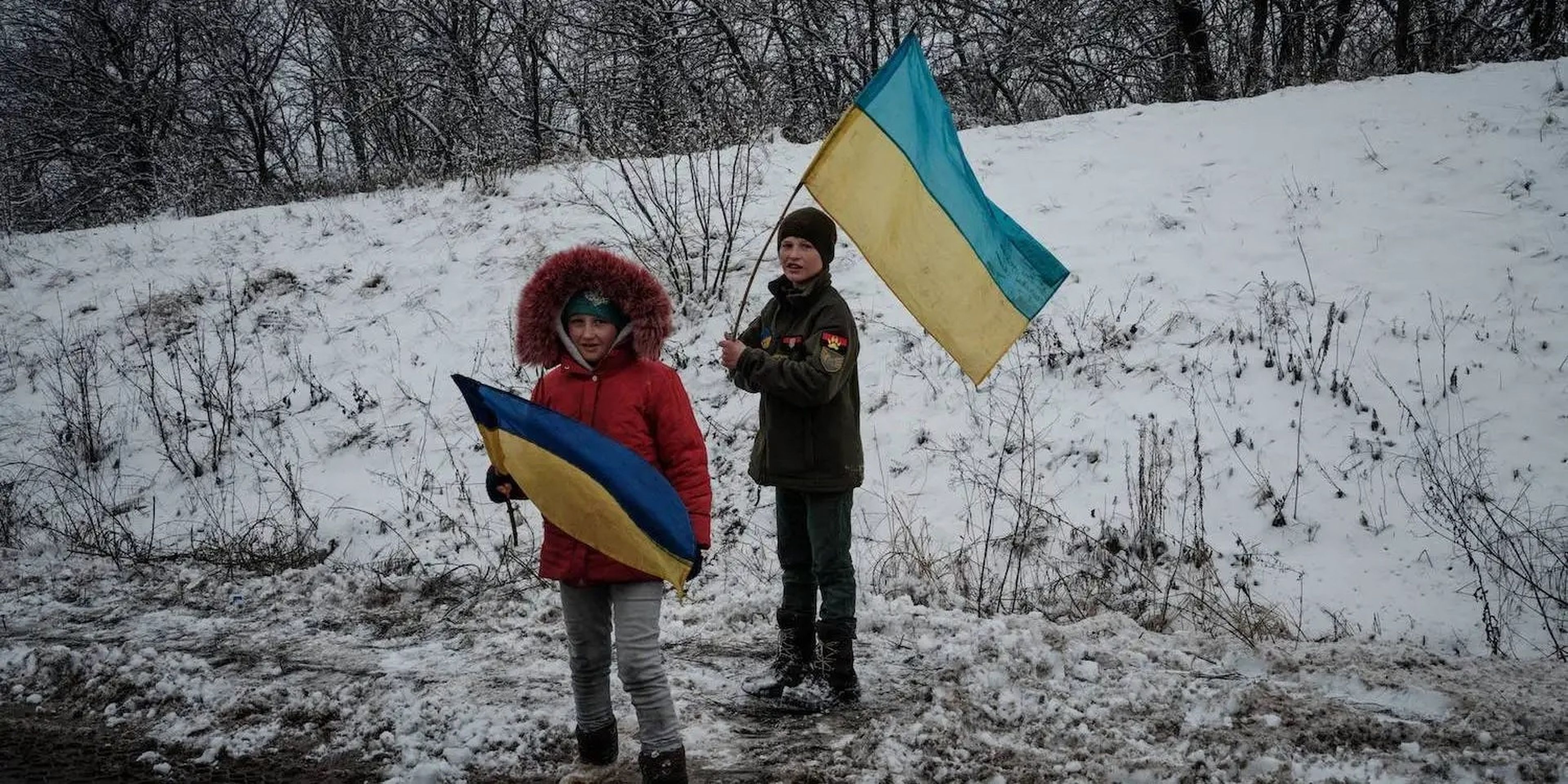 Unos niños sostienen banderas ucranianas en la carretera cerca de Sloviansk, Ucrania.