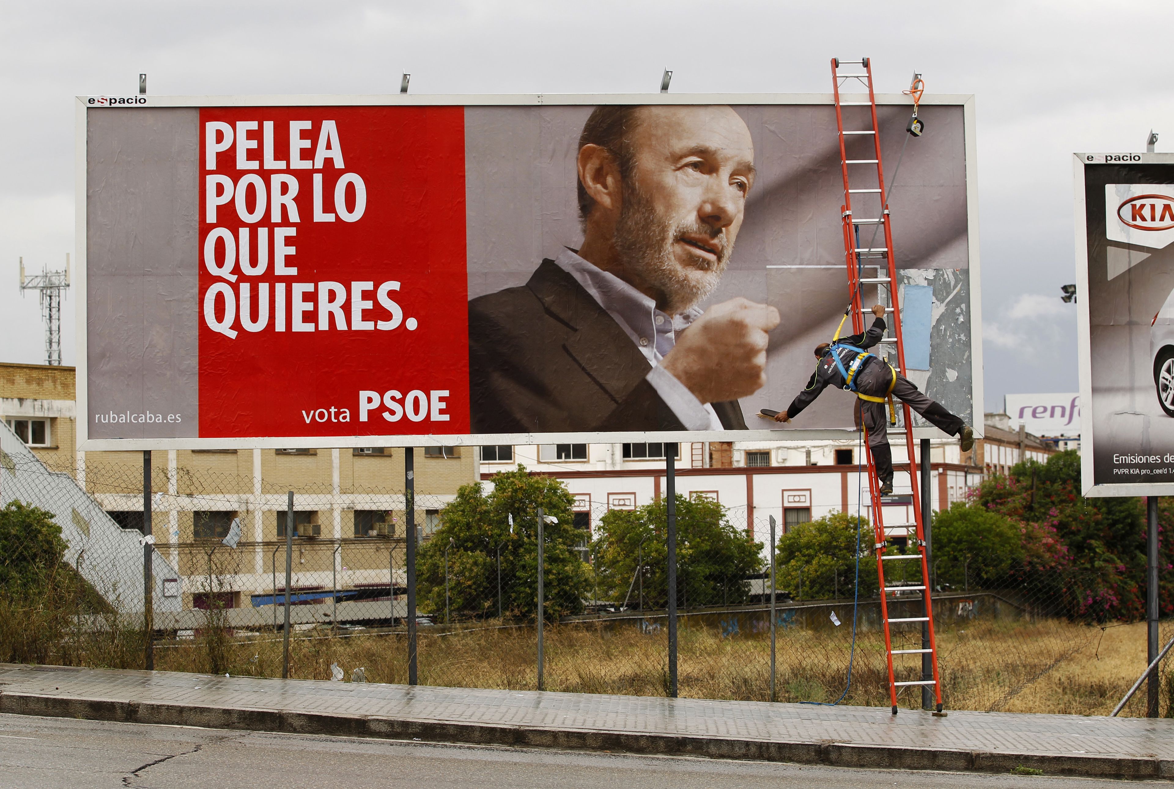 Un operario instala una valla publicitaria con el cartel electoral del PSOE para las generales de 2011.
