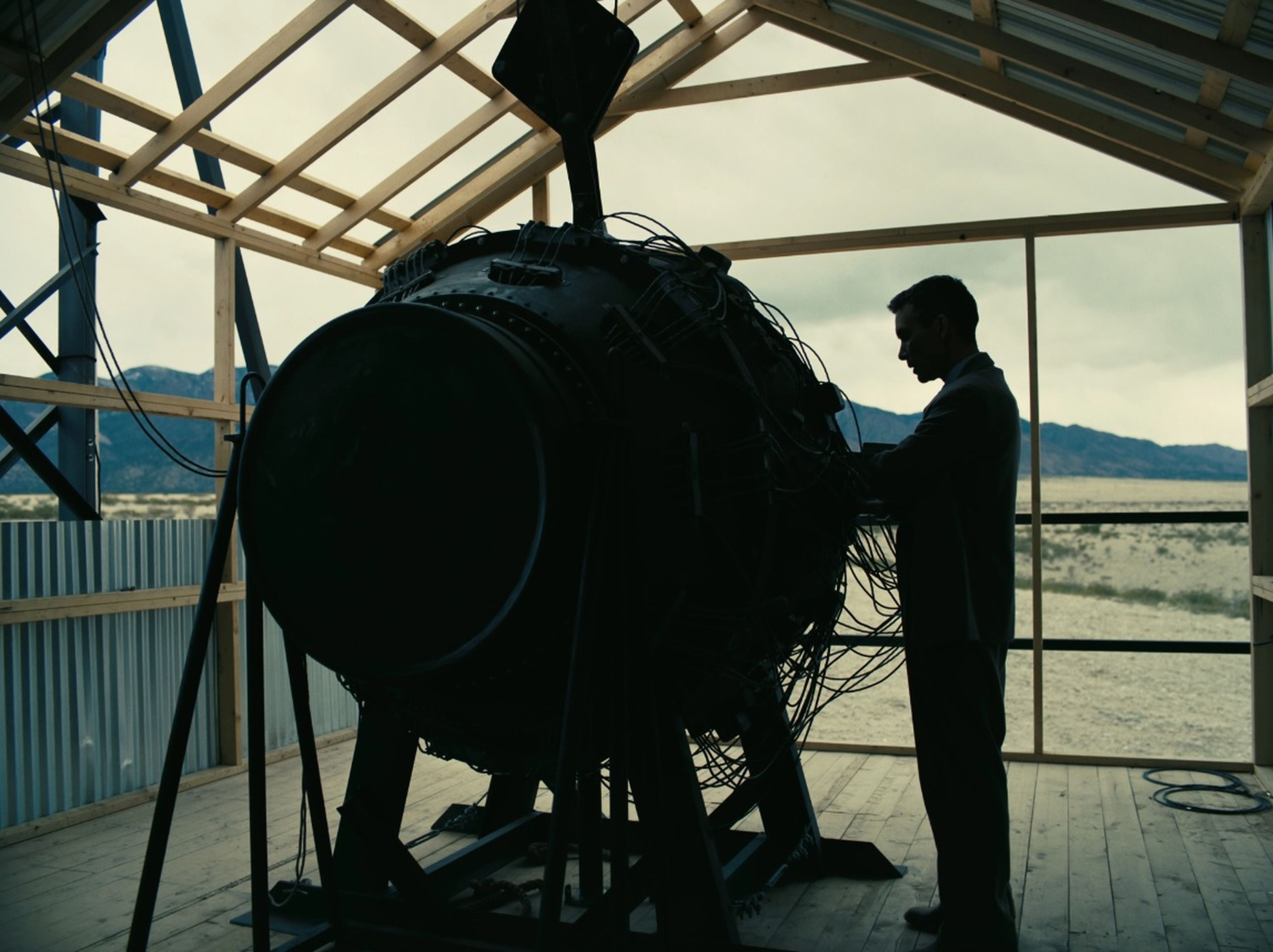 Cillian Murphy como Oppenheimer junto a la bomba de ensayo.