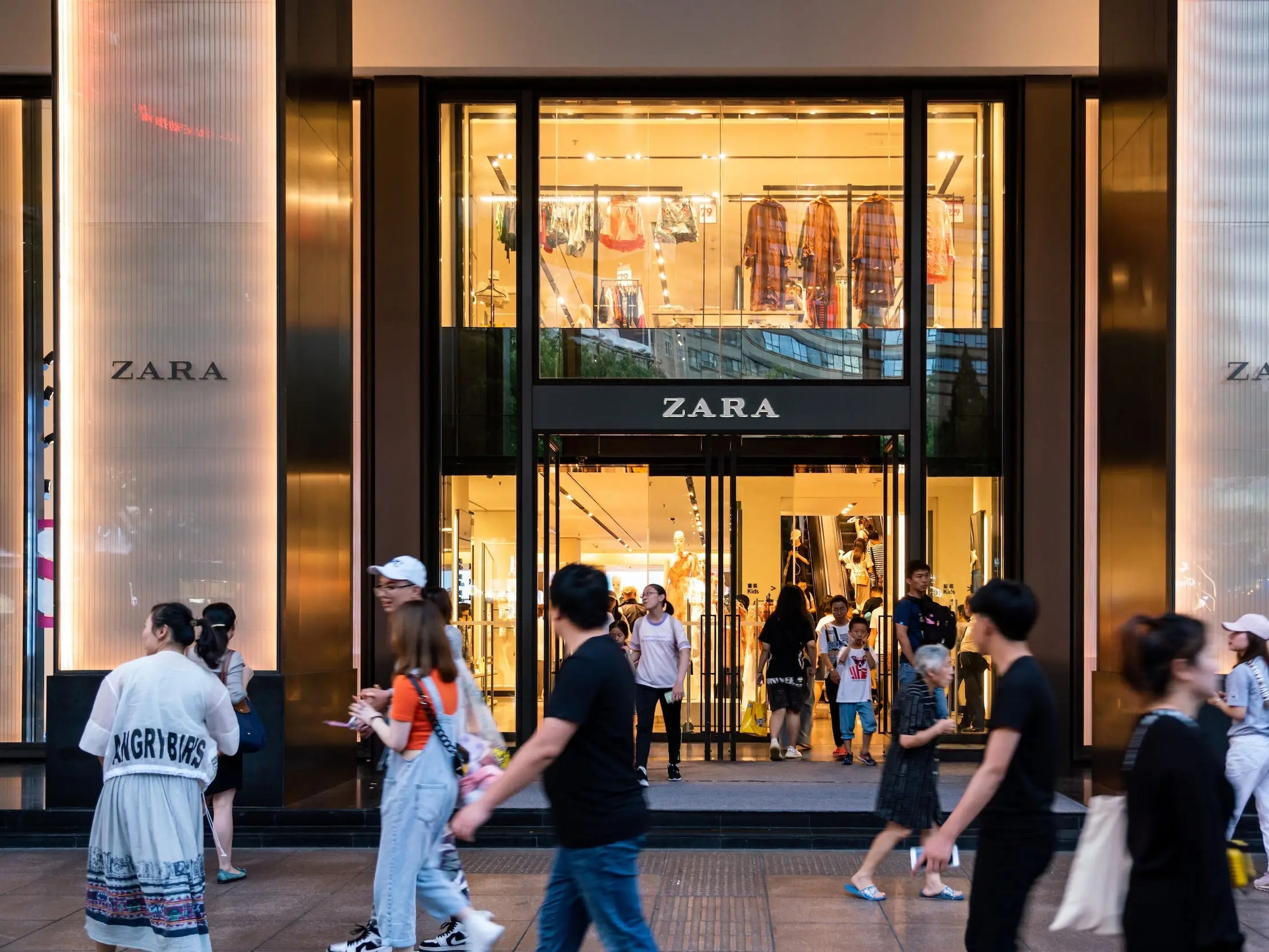 Peatones pasando por delante un Zara en Shanghái en 2019.