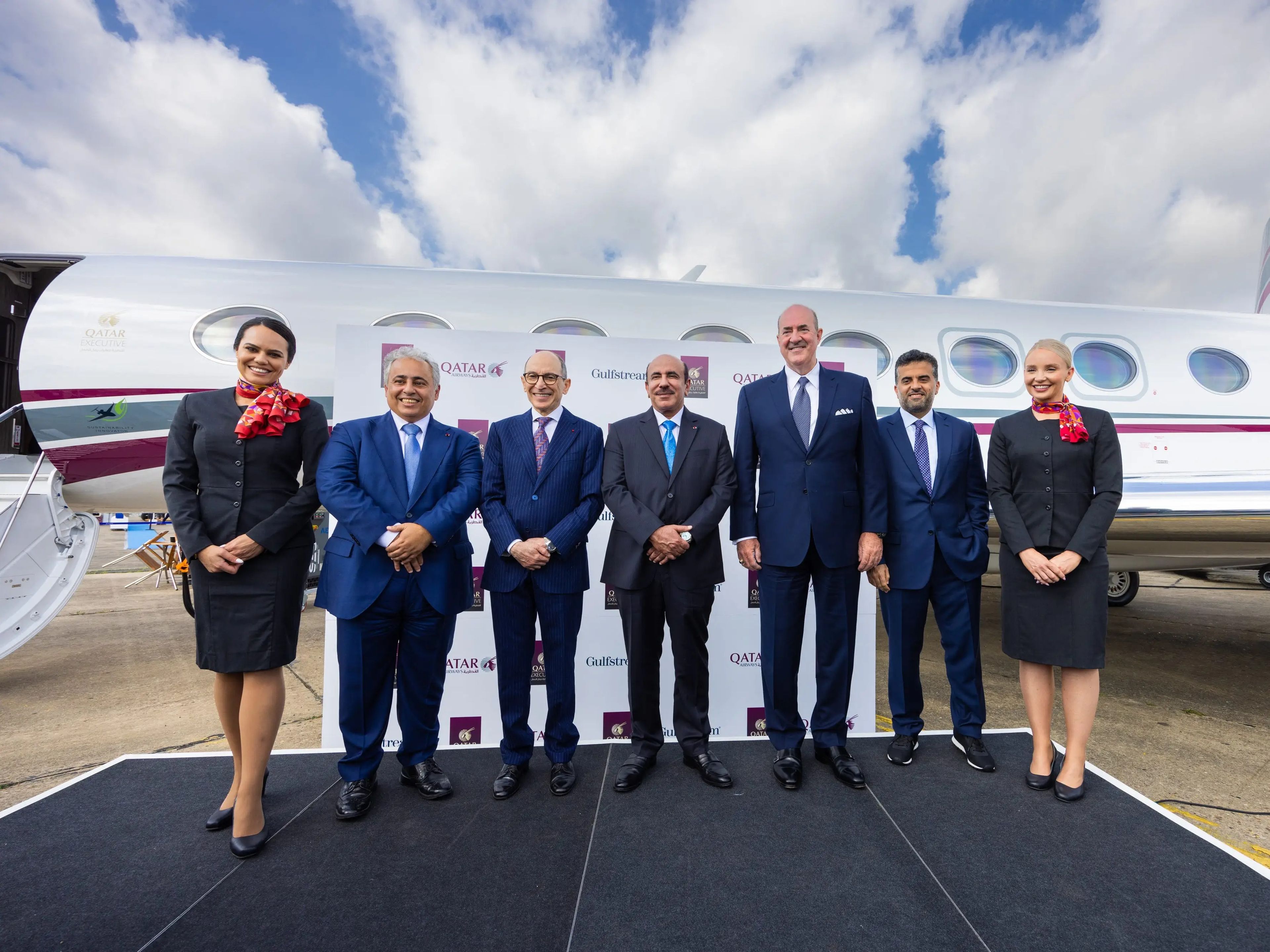 Qatar Airways CEO with cabin crew and other Qatar and Gulfstream executives standing in front of the G700.