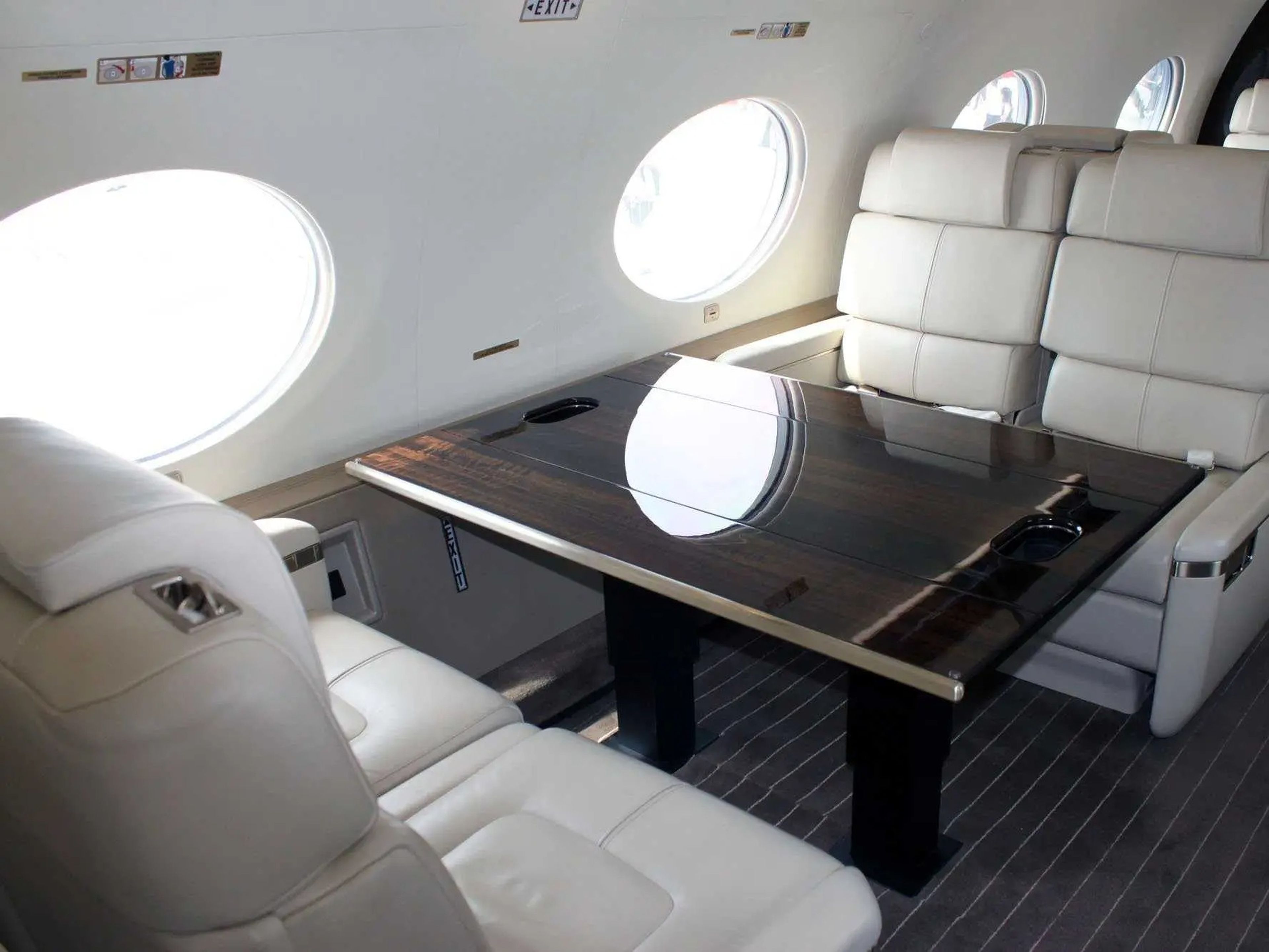 A row of seats around a table in the cabin of a Gulfstream G650 private jet.