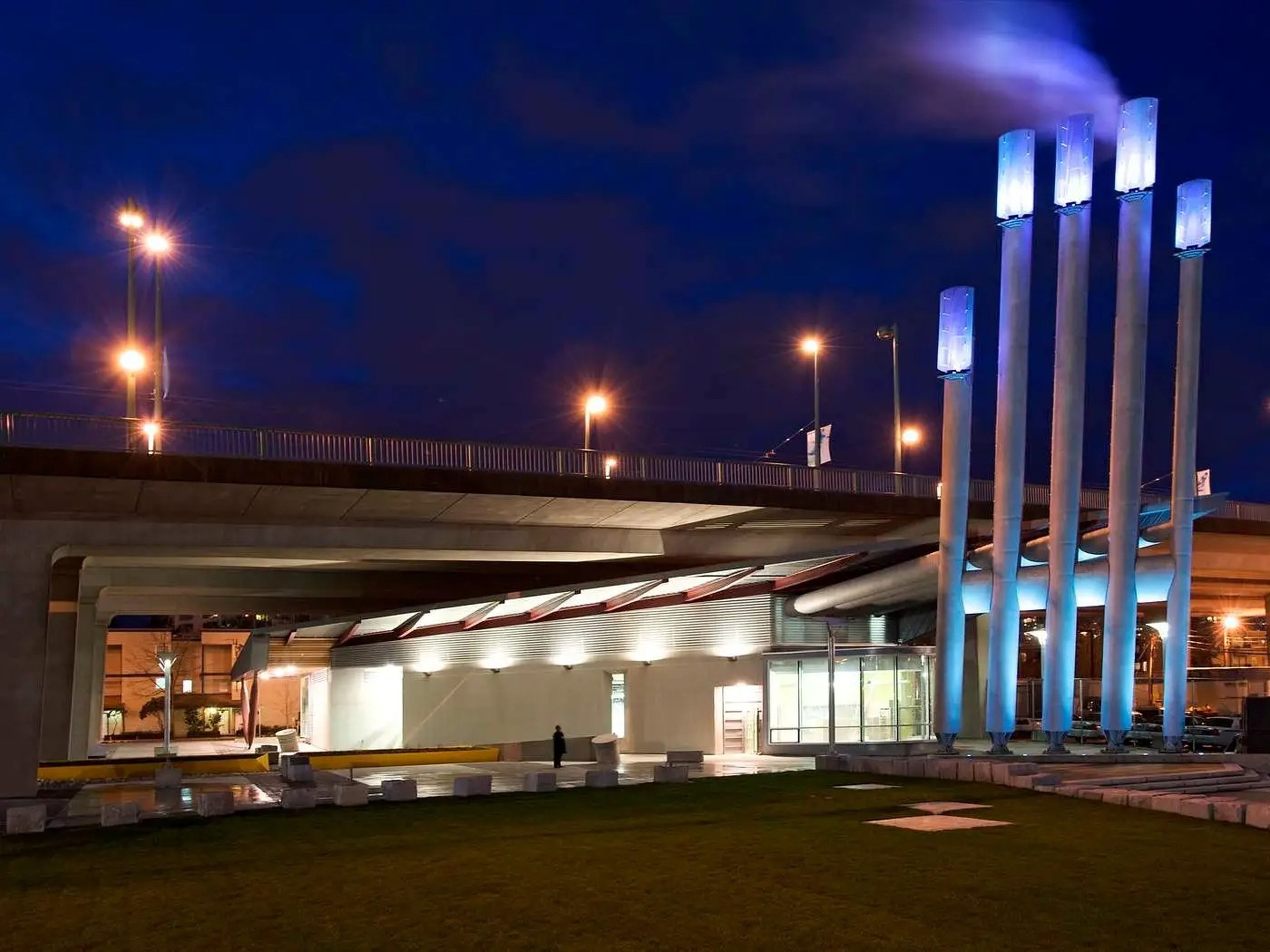 El centro de energía NEU está debajo de un puente. Las "uñas" -paneles LED en la parte superior de las calderas- cambian de color según la cantidad de energía que se extrae del sistema.