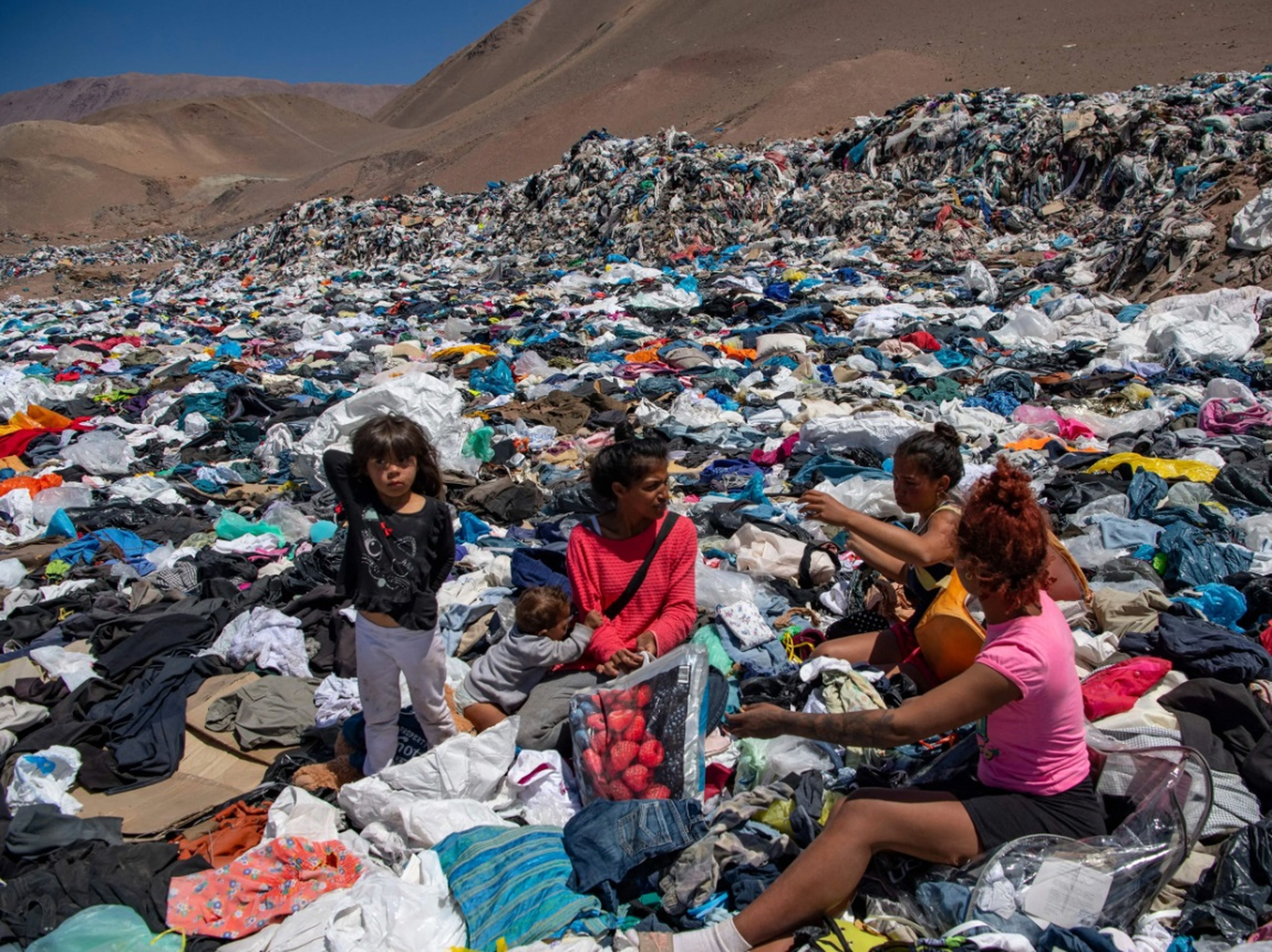Unas mujeres buscan ropa en desuso en el desierto de Atacama (Chile).