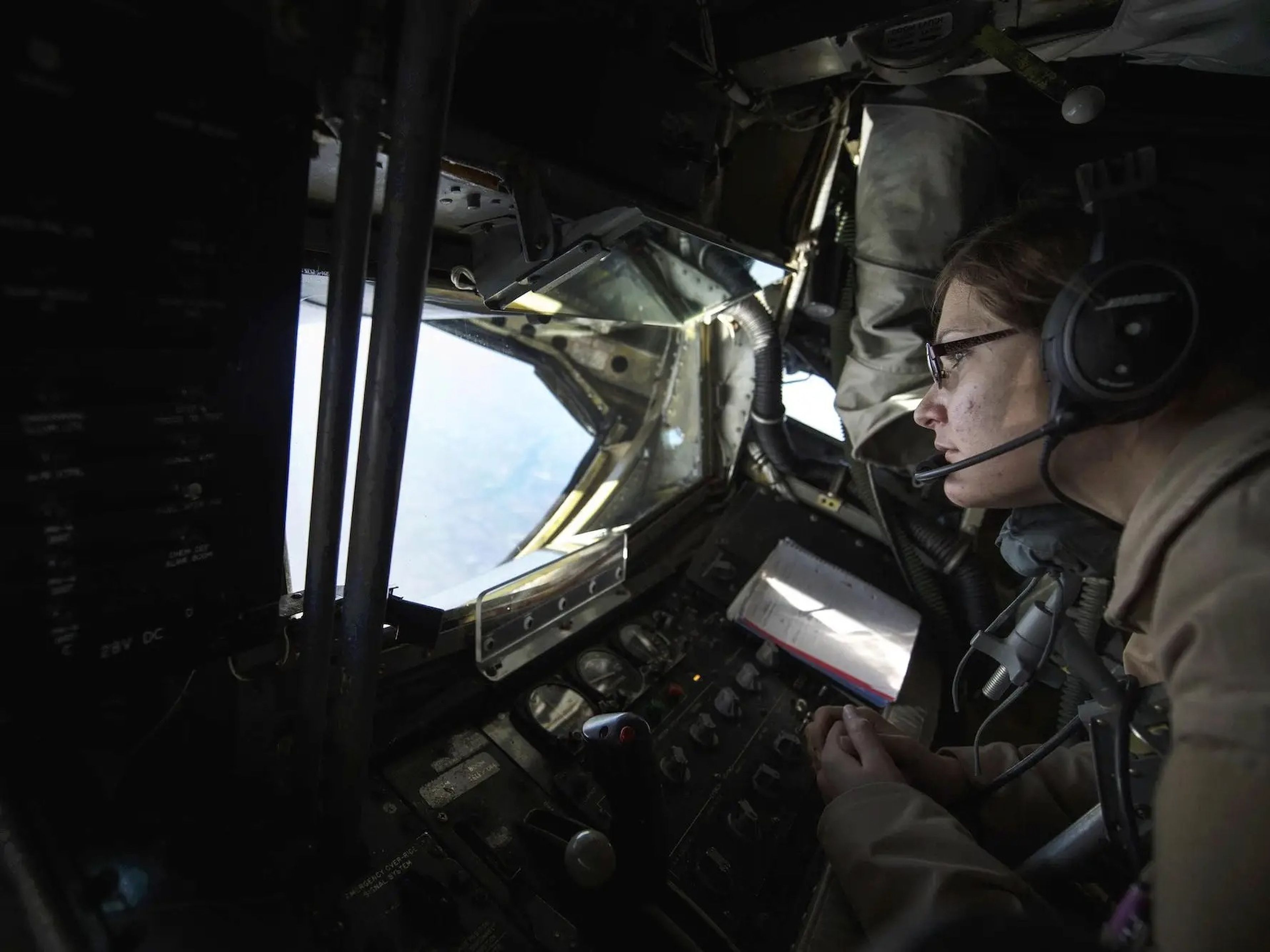 La aviadora superior de la Fuerza Aérea de Estados Unidos Rebekah McCormack mira por la ventanilla de la estación de boom de un KC-135 Stratotanker sobre Irak, 22 de diciembre de 2015.