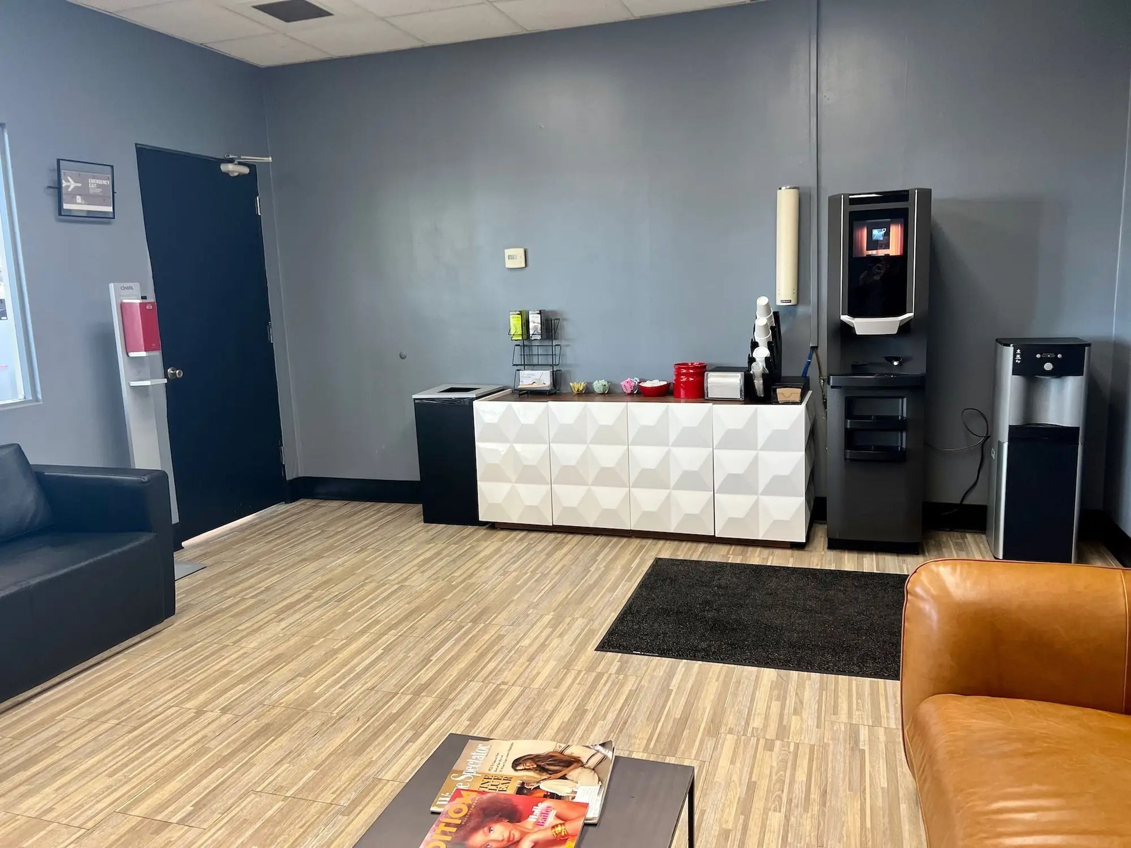 A view of the indoor lounge in JSX's private terminal with a coffee maker and two couches.