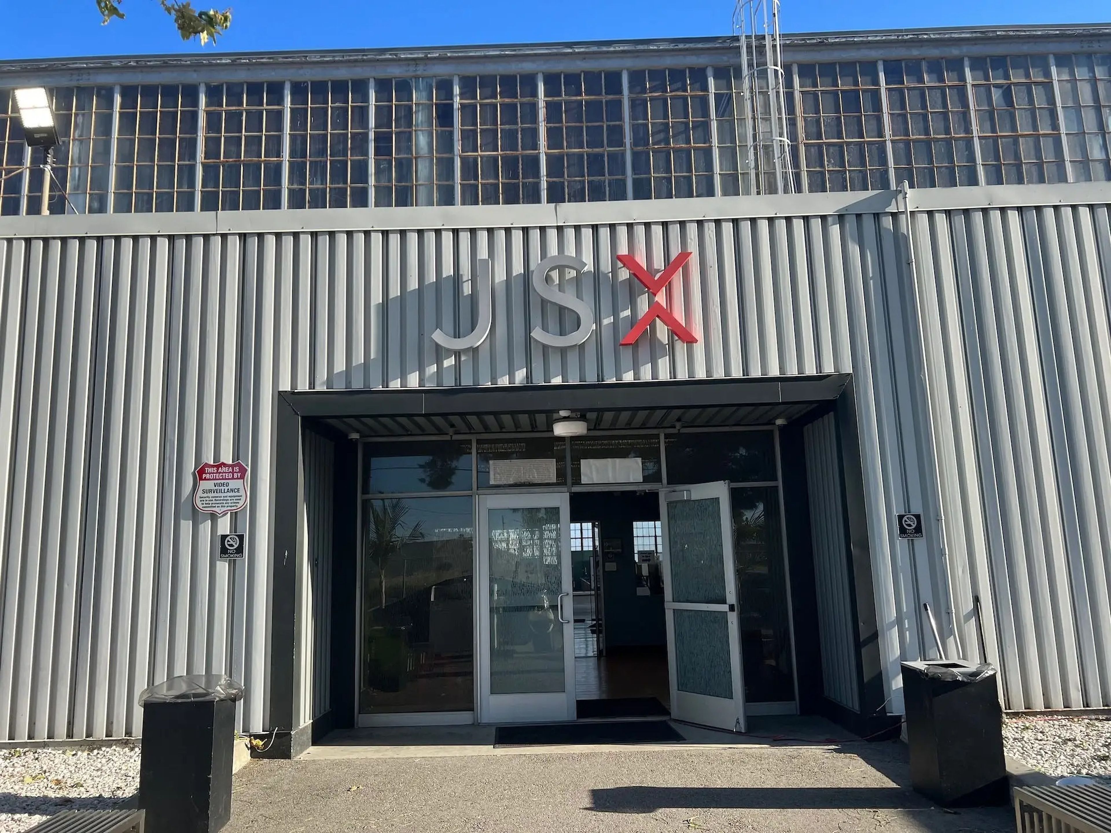 A view outside JSX's private terminal with a JSX logo above an open doorway.