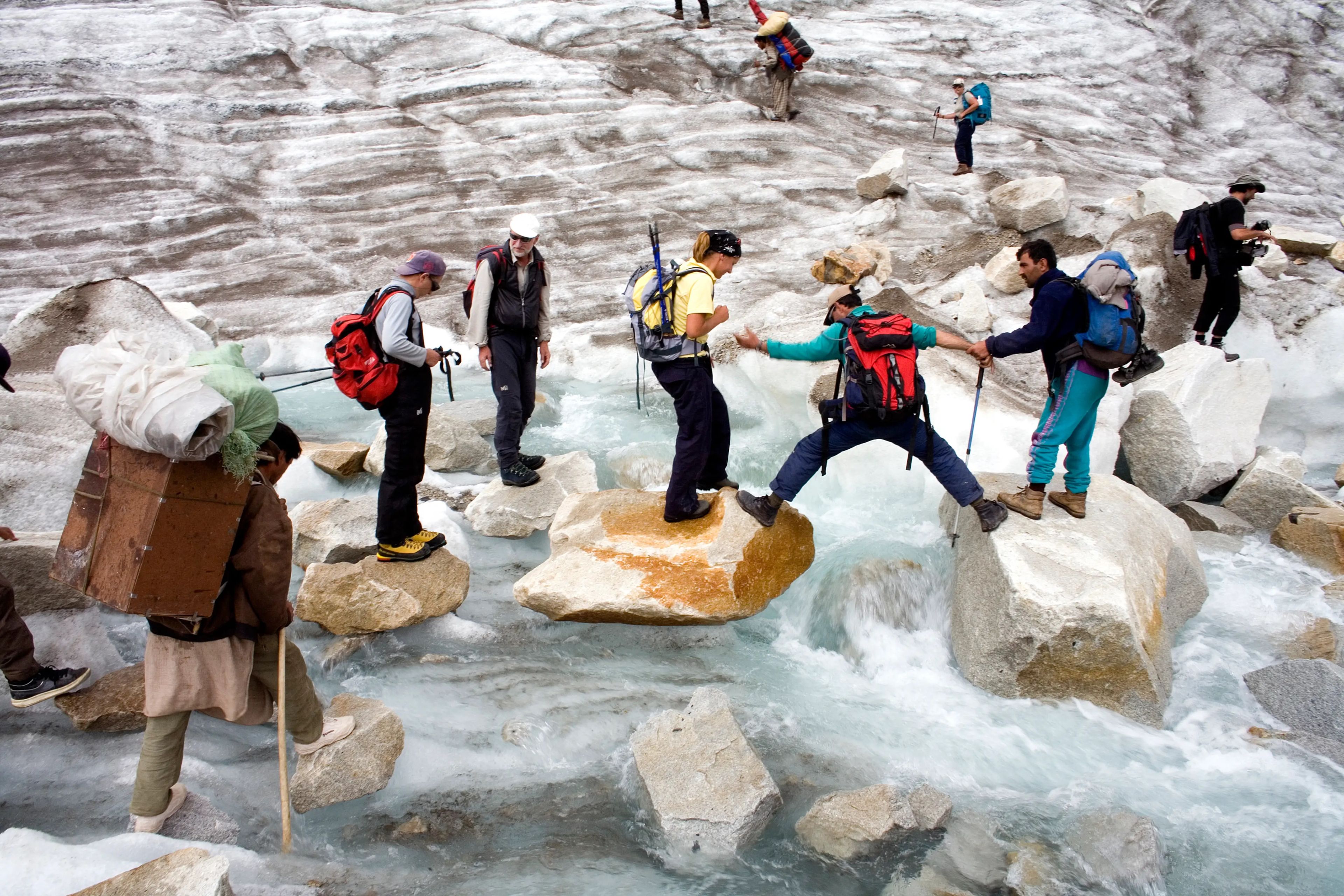 Ayudados por guías de montaña, unos excursionistas cruzan un arroyo en el glaciar Baltoro en 2006.