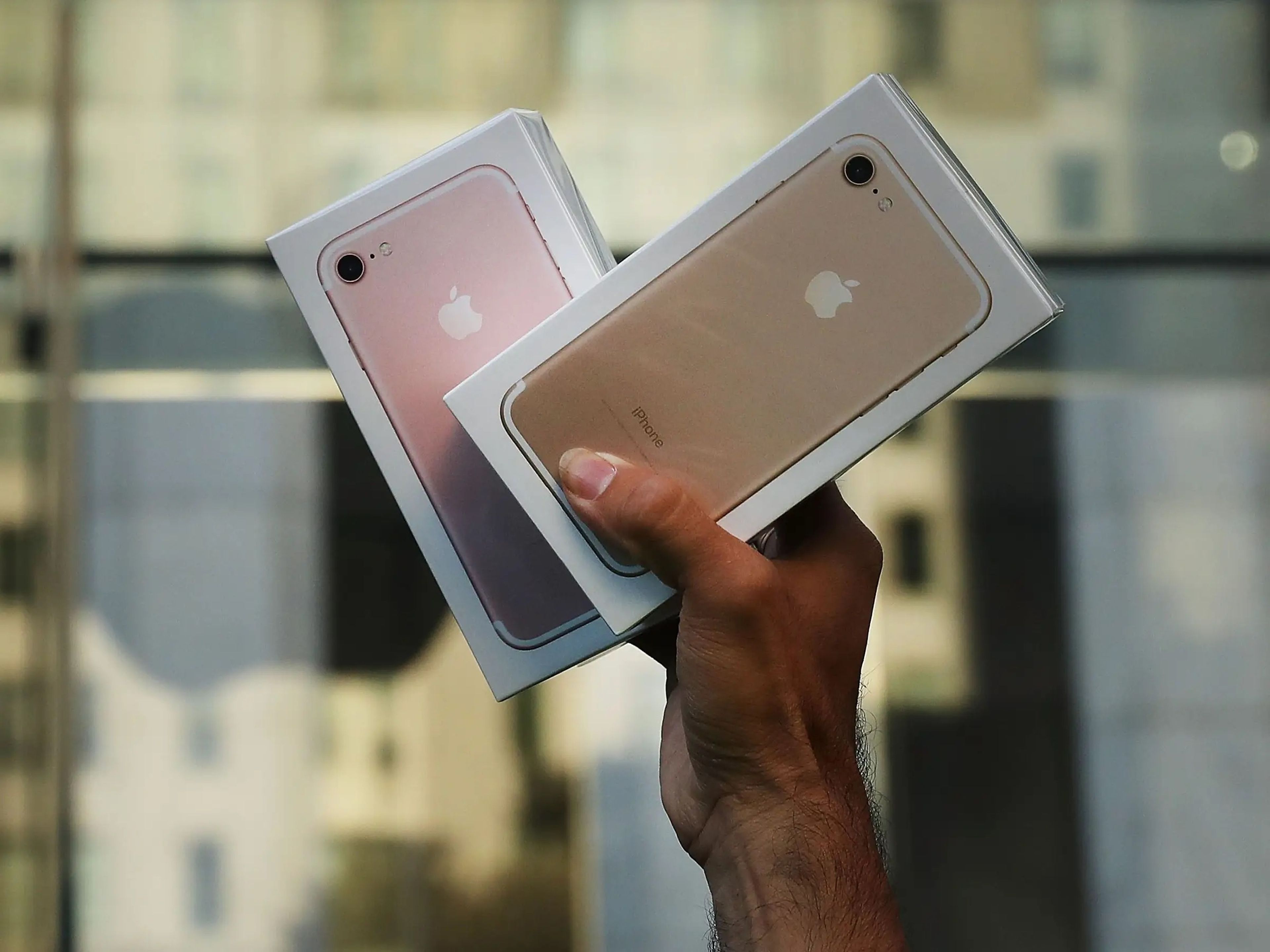 A hand holding a box for an iPhone 7 and iPhone 7 Plus