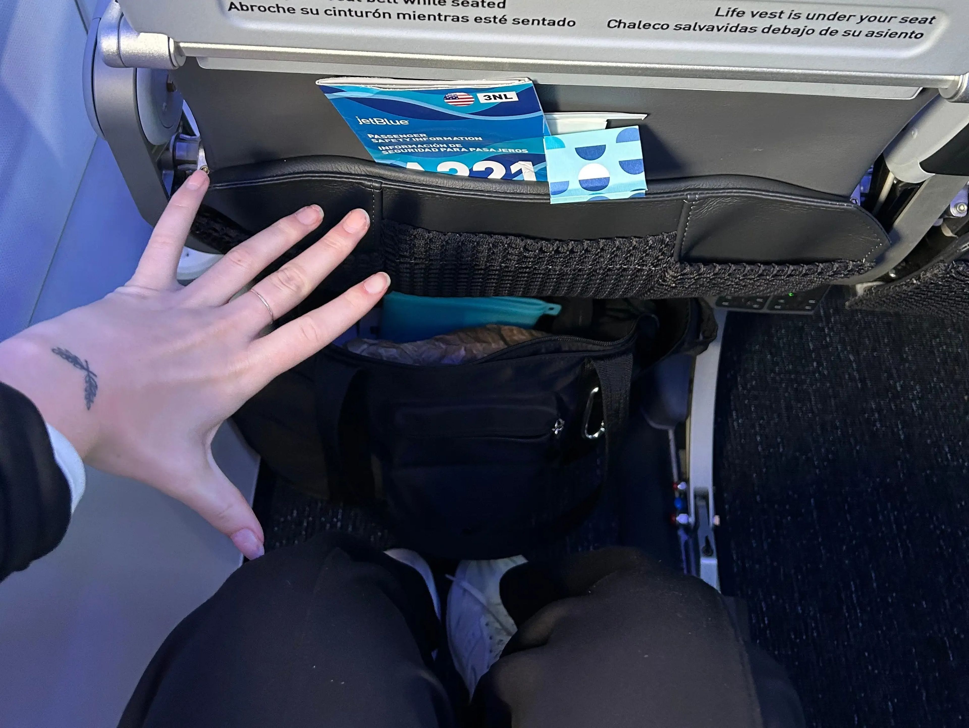 Insider's reporter demonstrating the amount of legroom in an Even More Space seat.