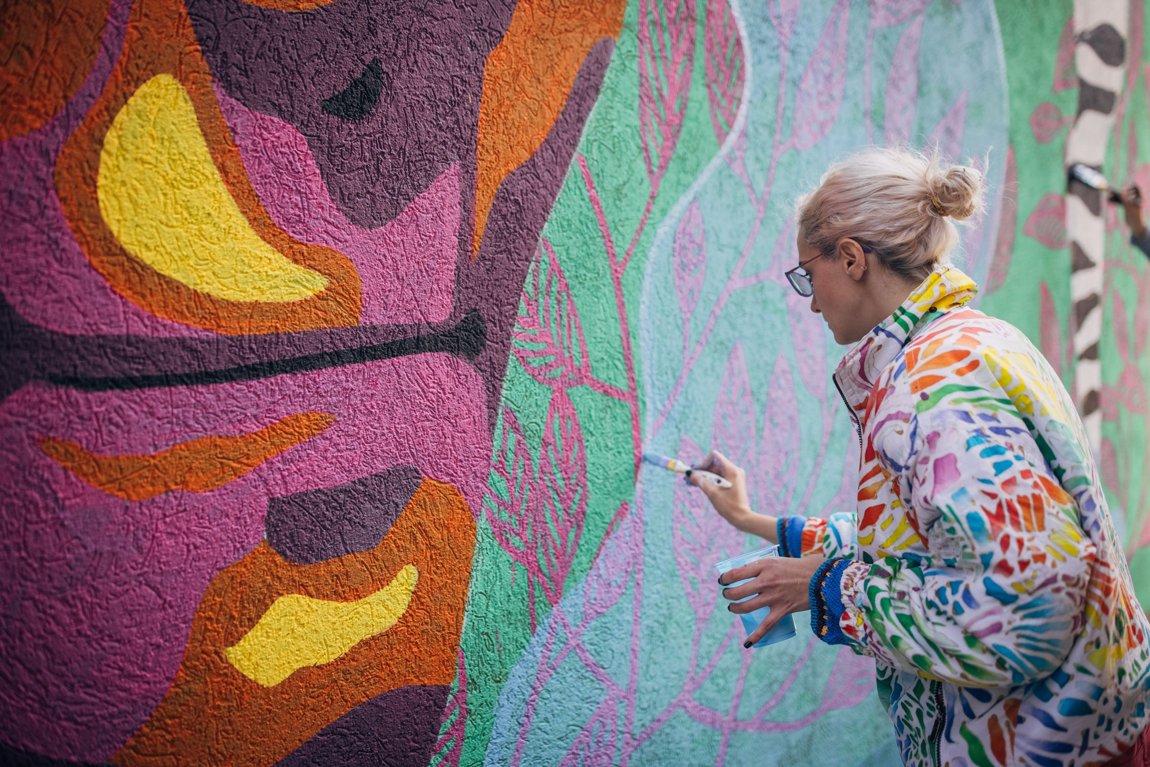 Mujer pintando un mural en la pared