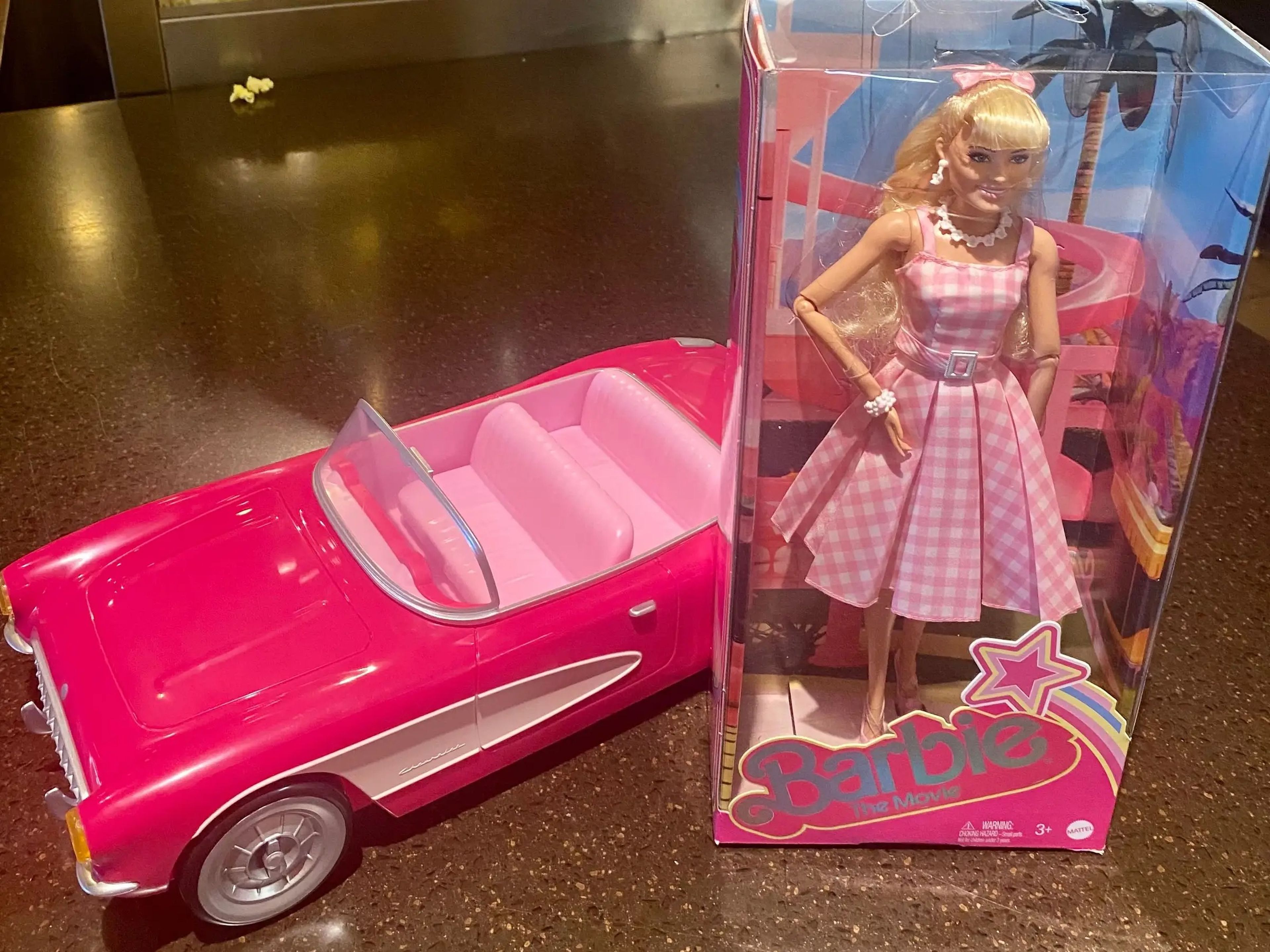 Muñeca Barbie vestida como en la película con su coche descapotable.