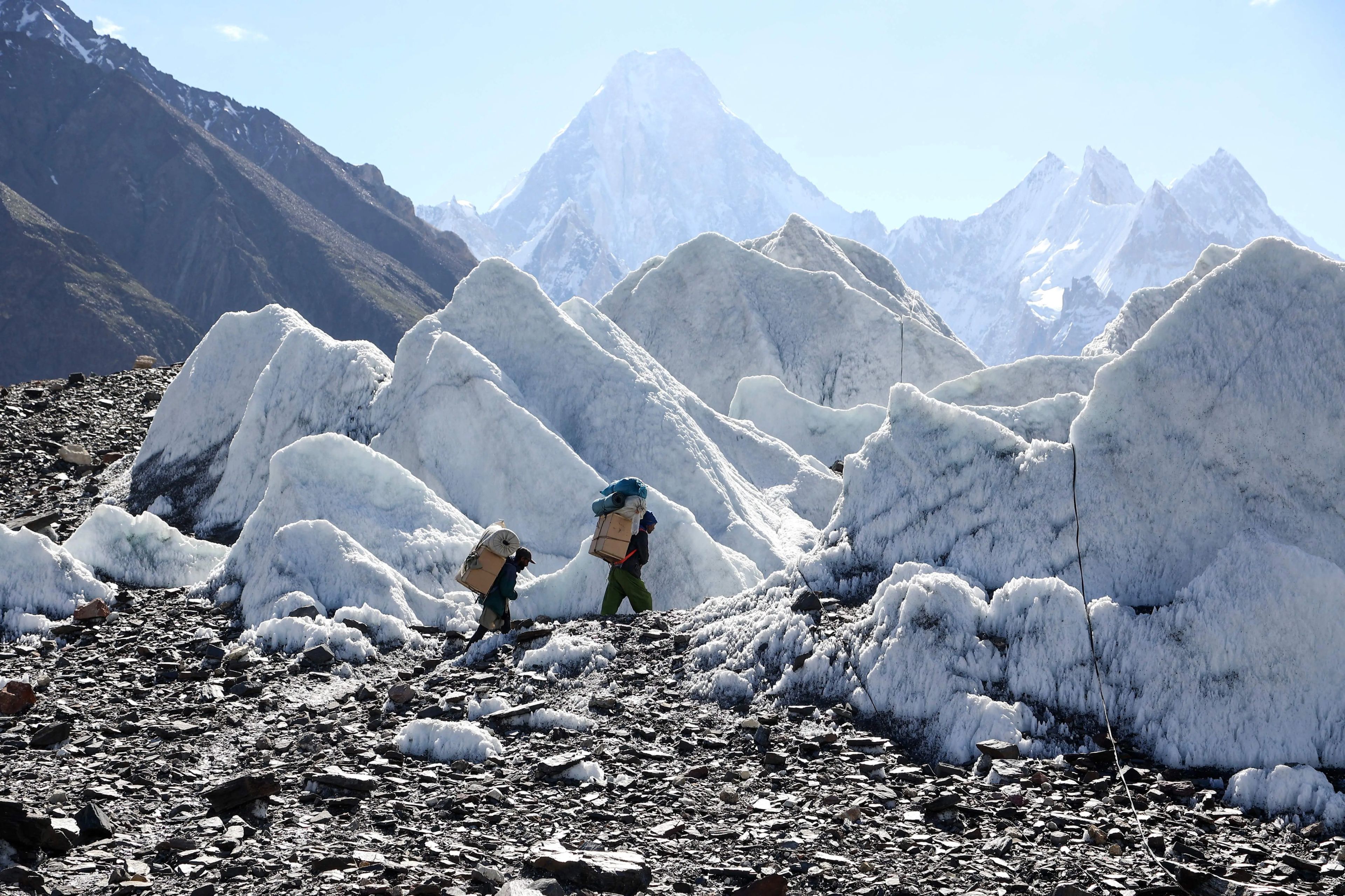 Porteadores pakistaníes de caminata en el glaciar Baltoro, a lo largo de la ruta entre Askole y K2.