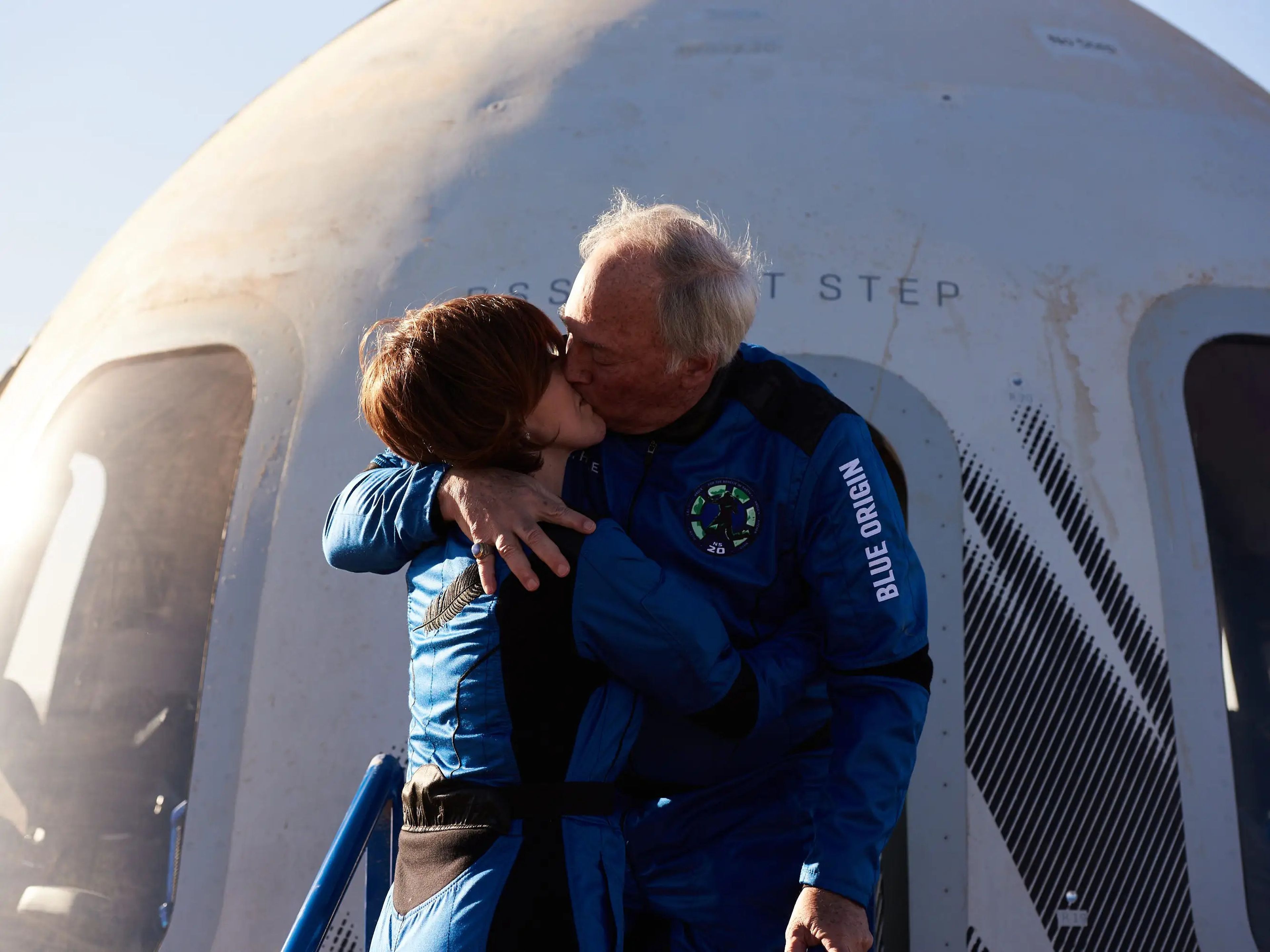 Sharon y Marc Hagle se besan frente a la cápsula espacial de Blue Origin después de un breve vuelo espacial.