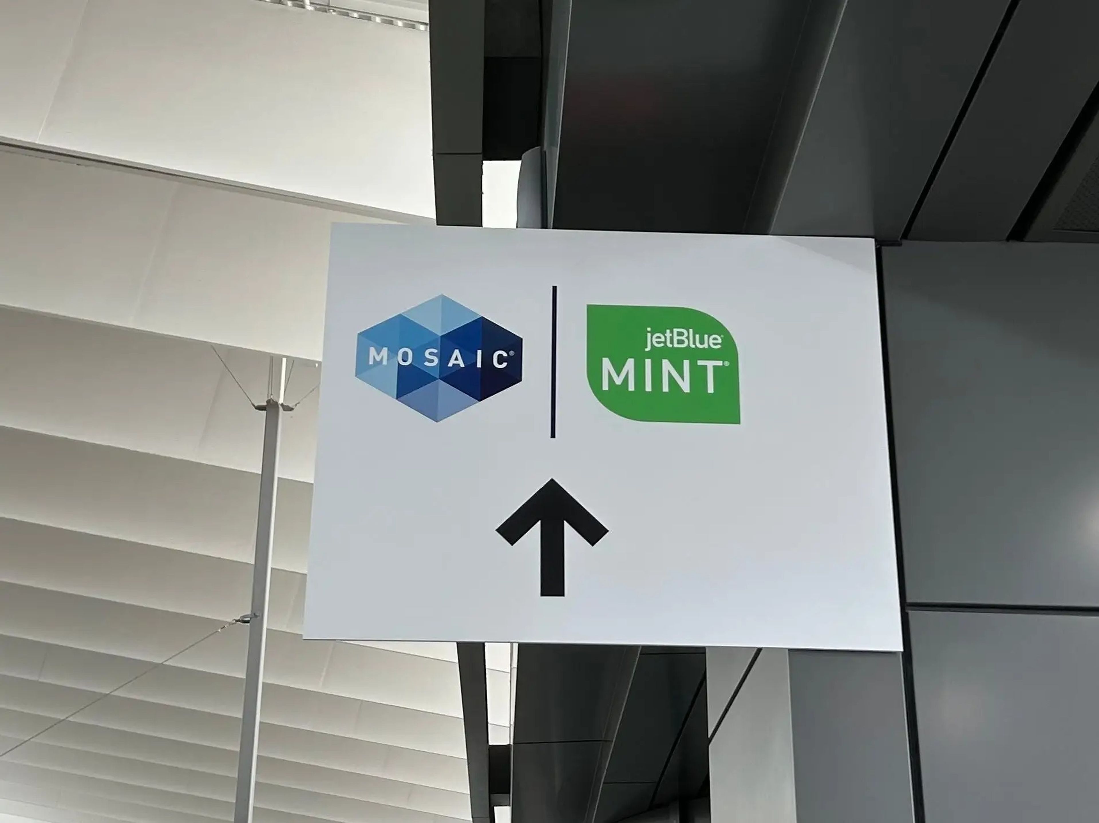 A sign pointing to priority security for JetBlue Mint passengers.