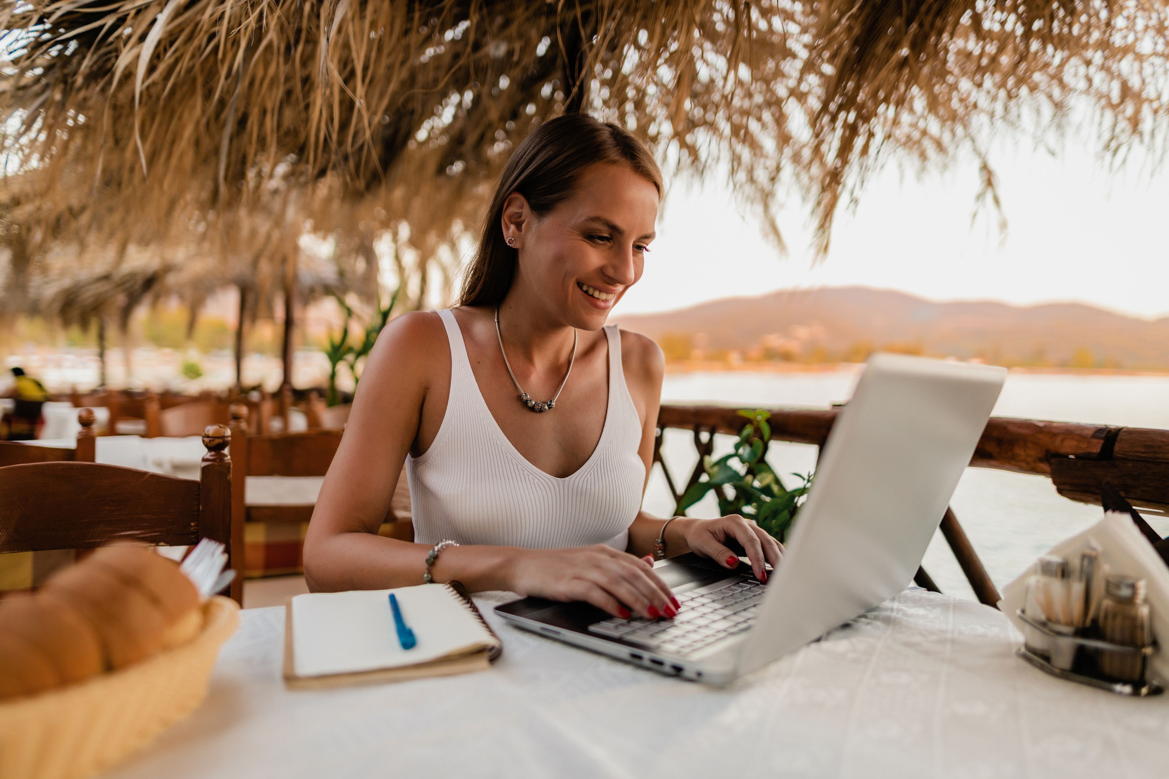 Trabajadora autónoma, mujer joven con ordenador de vacaciones