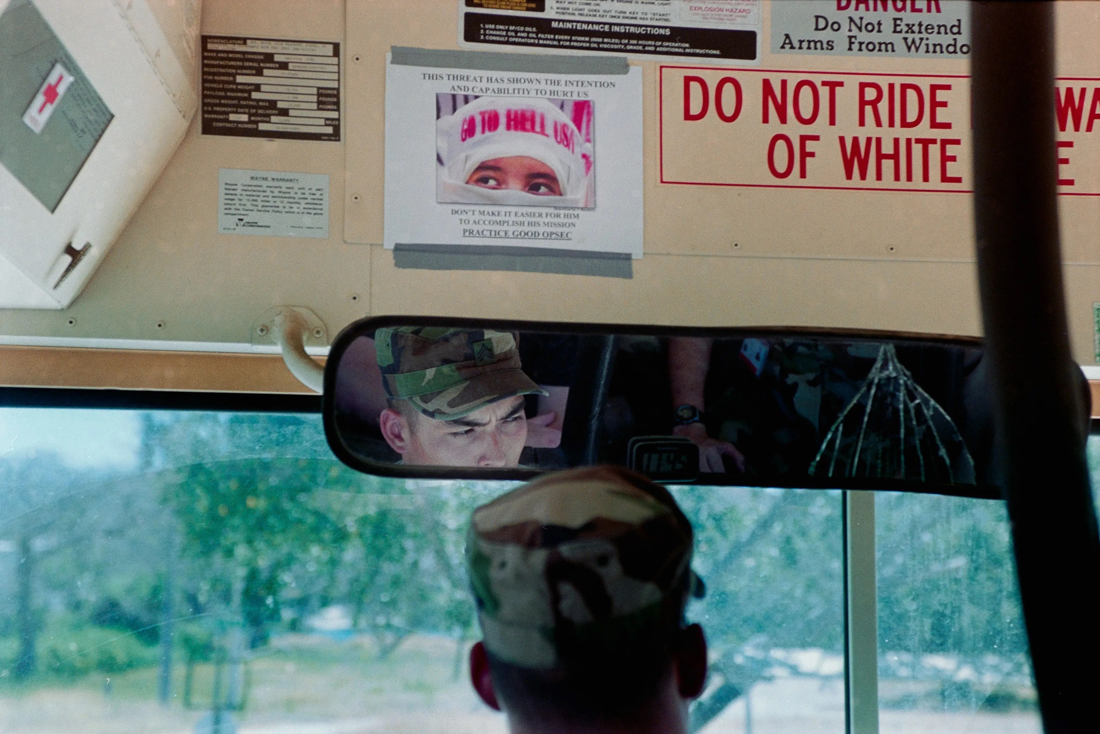Un autobús conducido por marines con un cartel en el que aparece la foto de una persona con pañuelo en la cabeza que dice "GO TO HELL USA". El texto alrededor de la foto dice: "Esta amenaza ha demostrado la capacidad y la intención de hacernos daño".