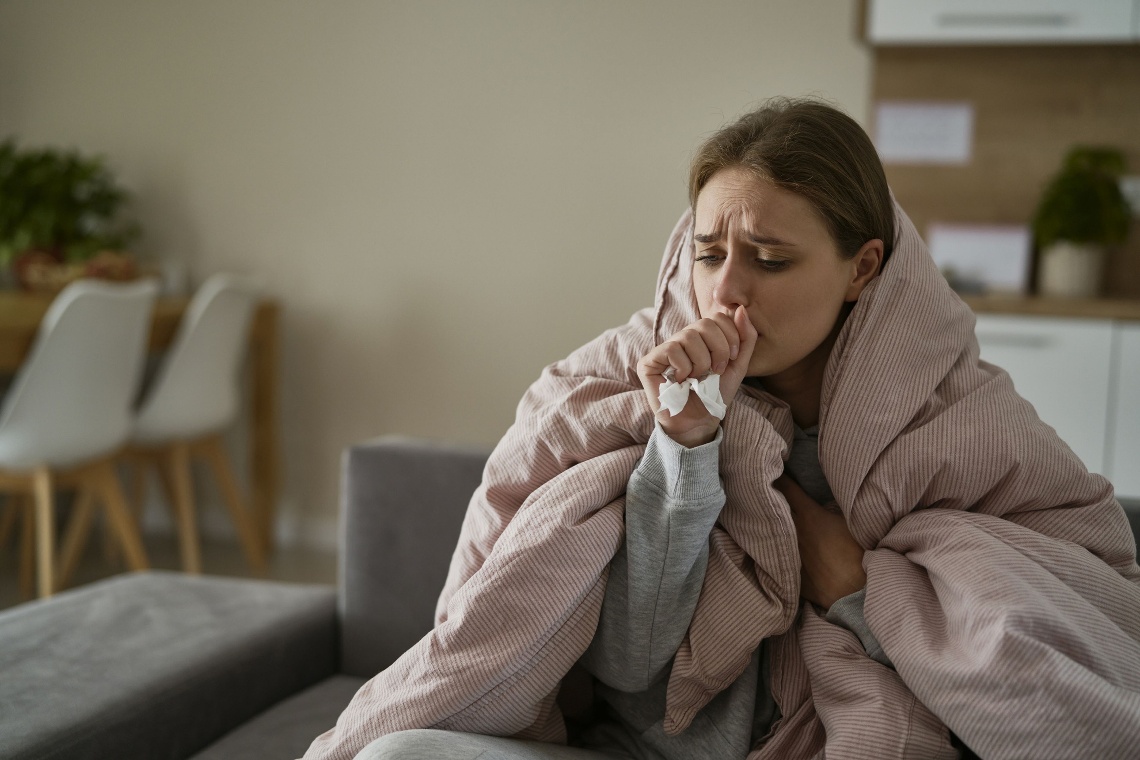 Chica arropada con gripe