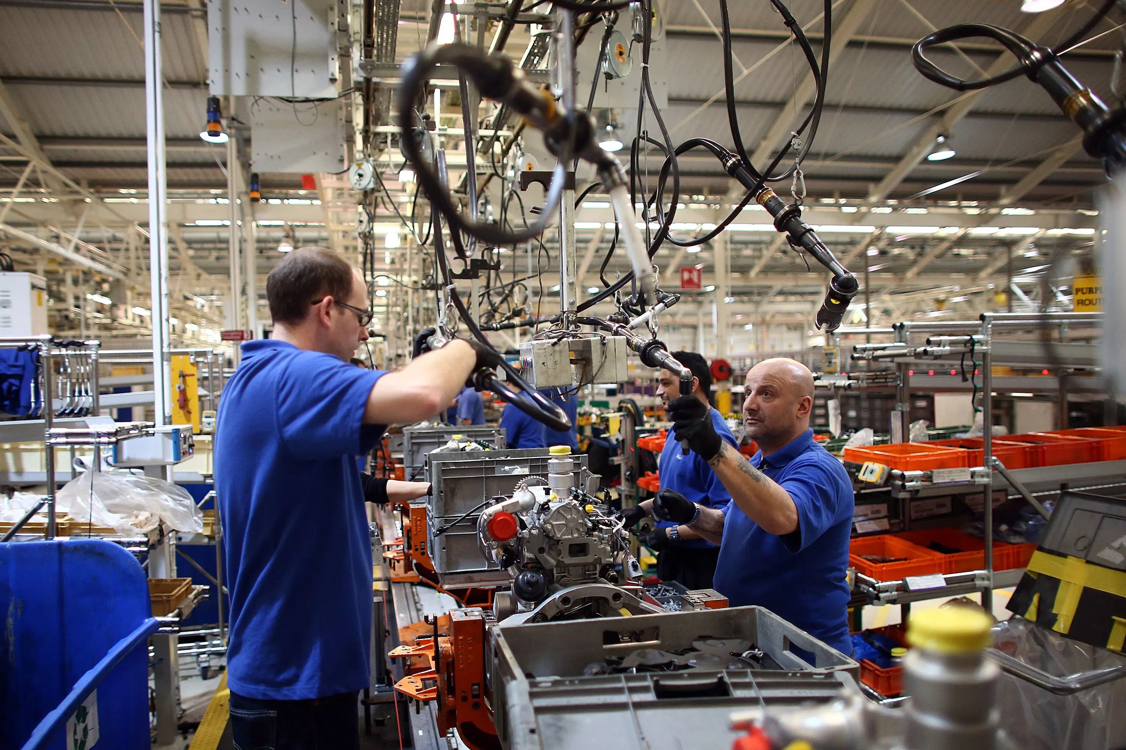 Empleados trabajan en una línea de producción de motores en una fábrica de Ford el 13 de enero de 2015 en Dagenham, Inglaterra.