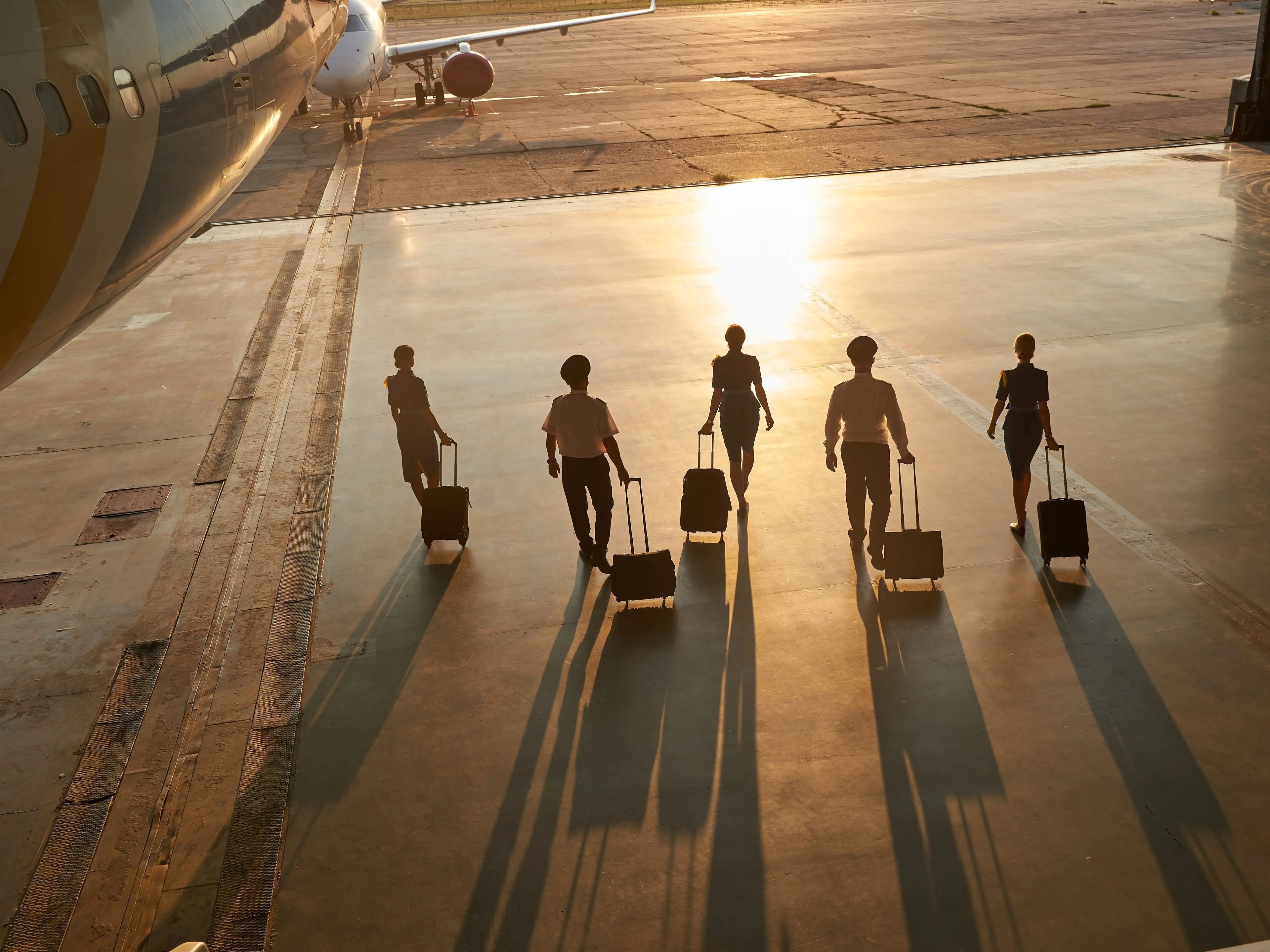 Flight attendants walking on a runway.