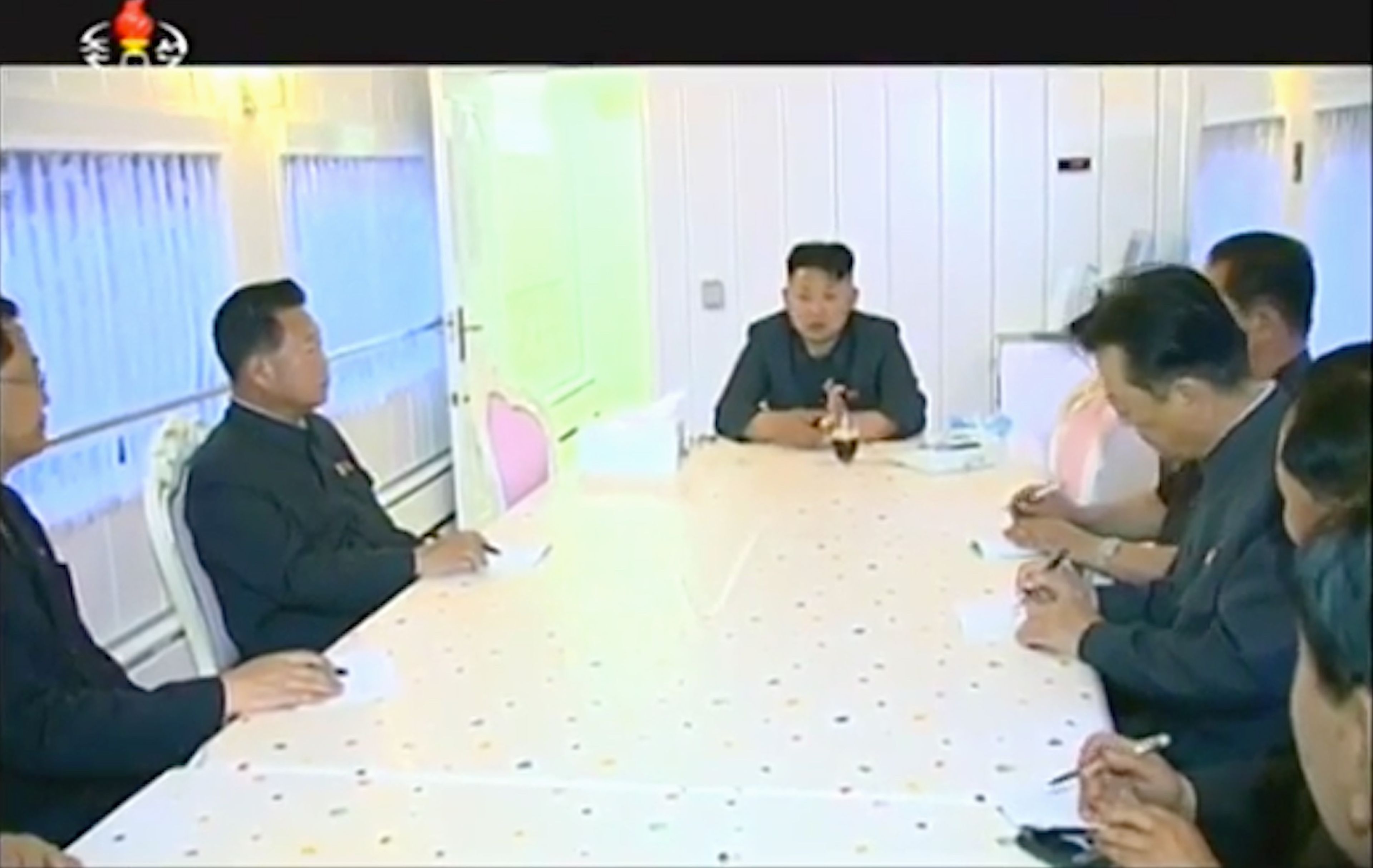 Kim Jong Un en una reunión dentro del tren en una sala totalmente blanca.