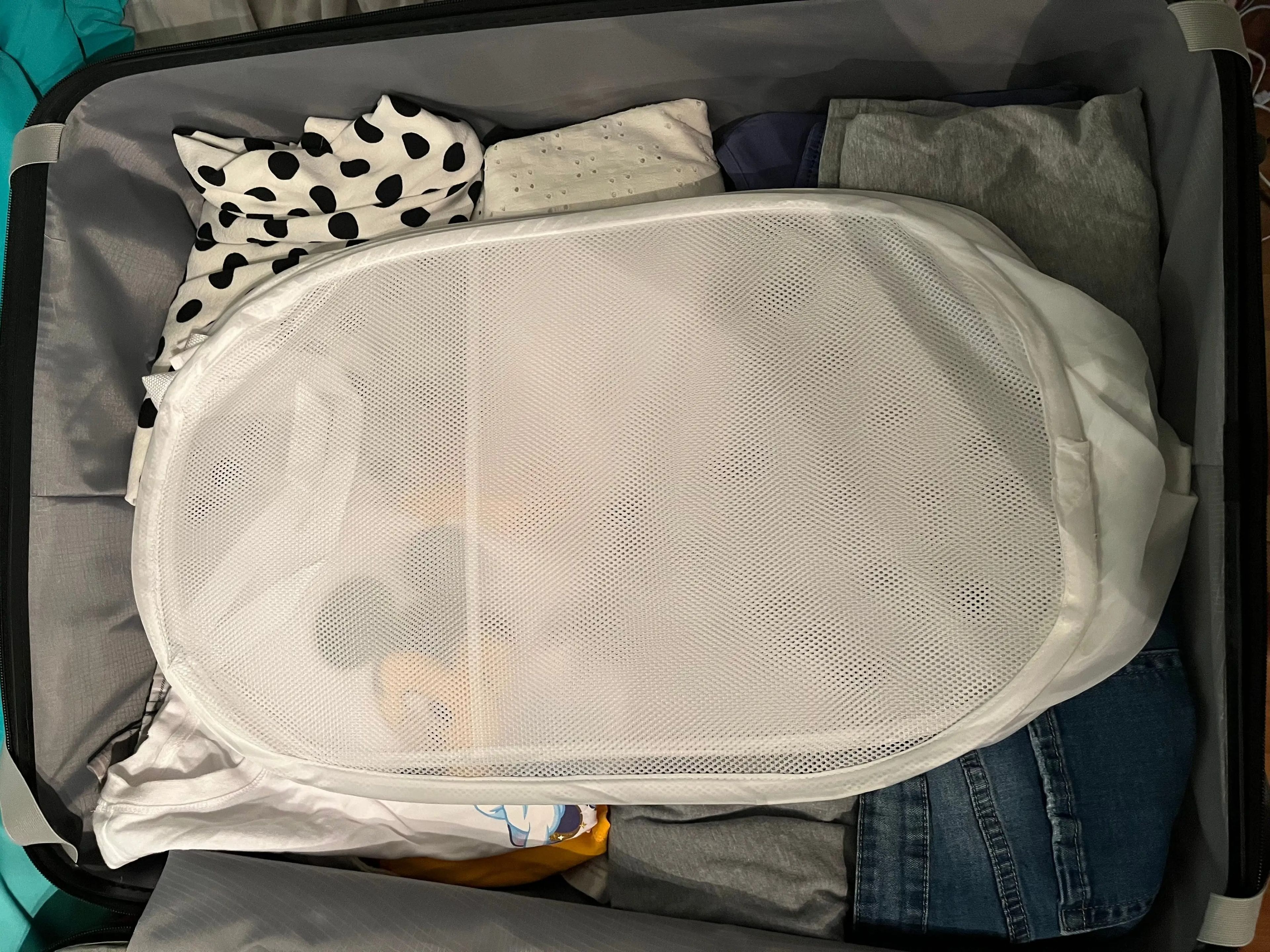 laundry hamper packed on top of a suitcase