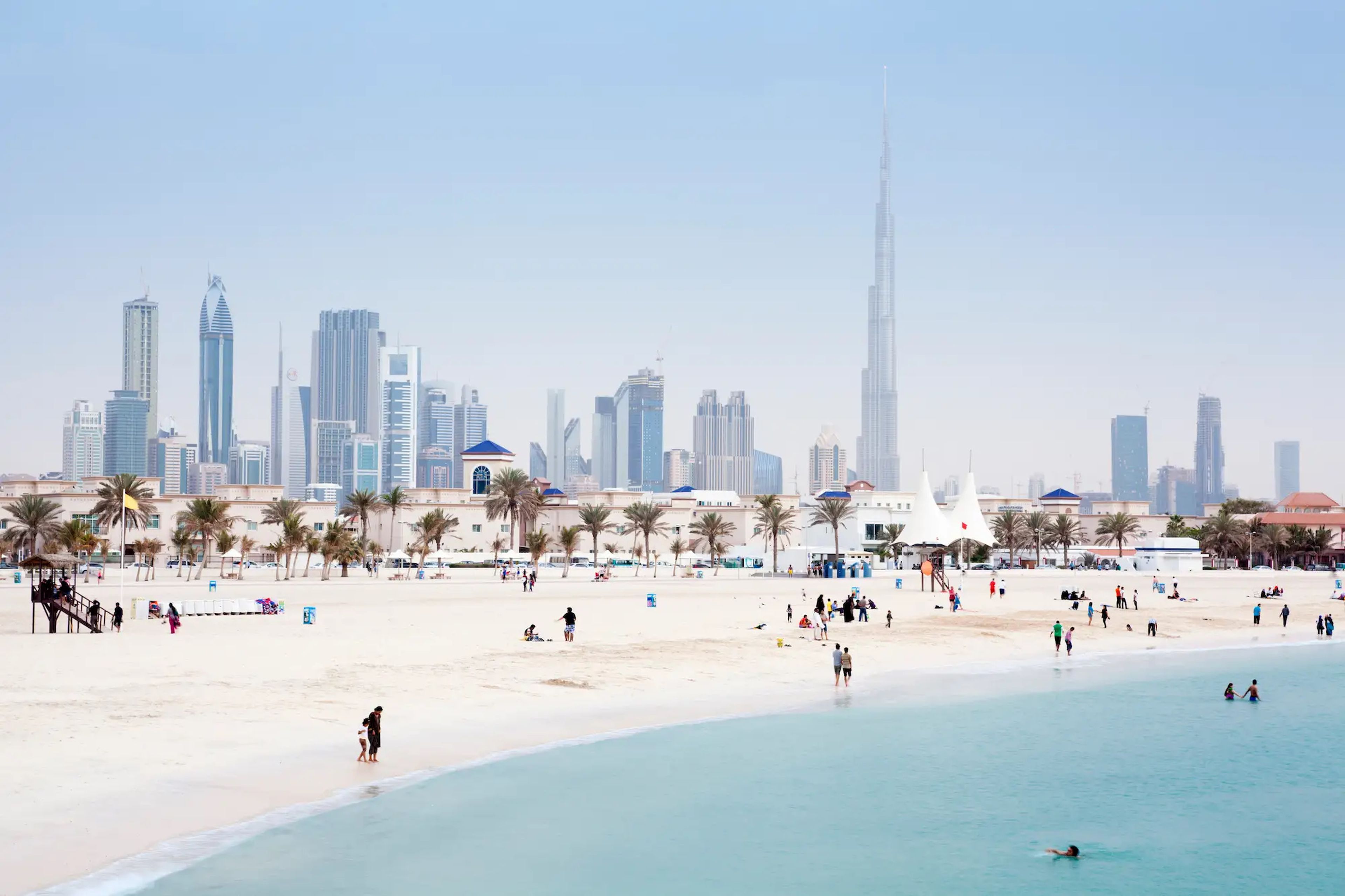 El skyline de Dubai y la playa Jumeirah Open Beach en los Emiratos Árabes Unidos.