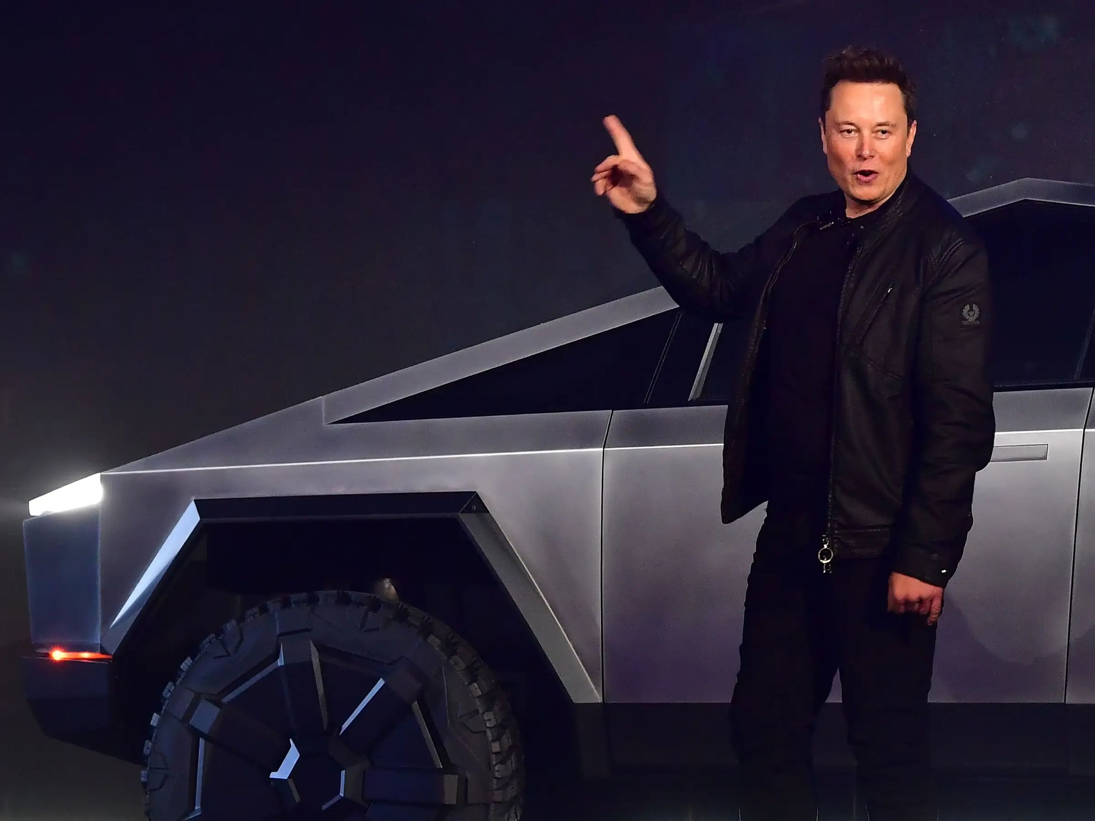 Elon Musk, CEO de Tesla, hace un gesto hacia un Cybertruck.