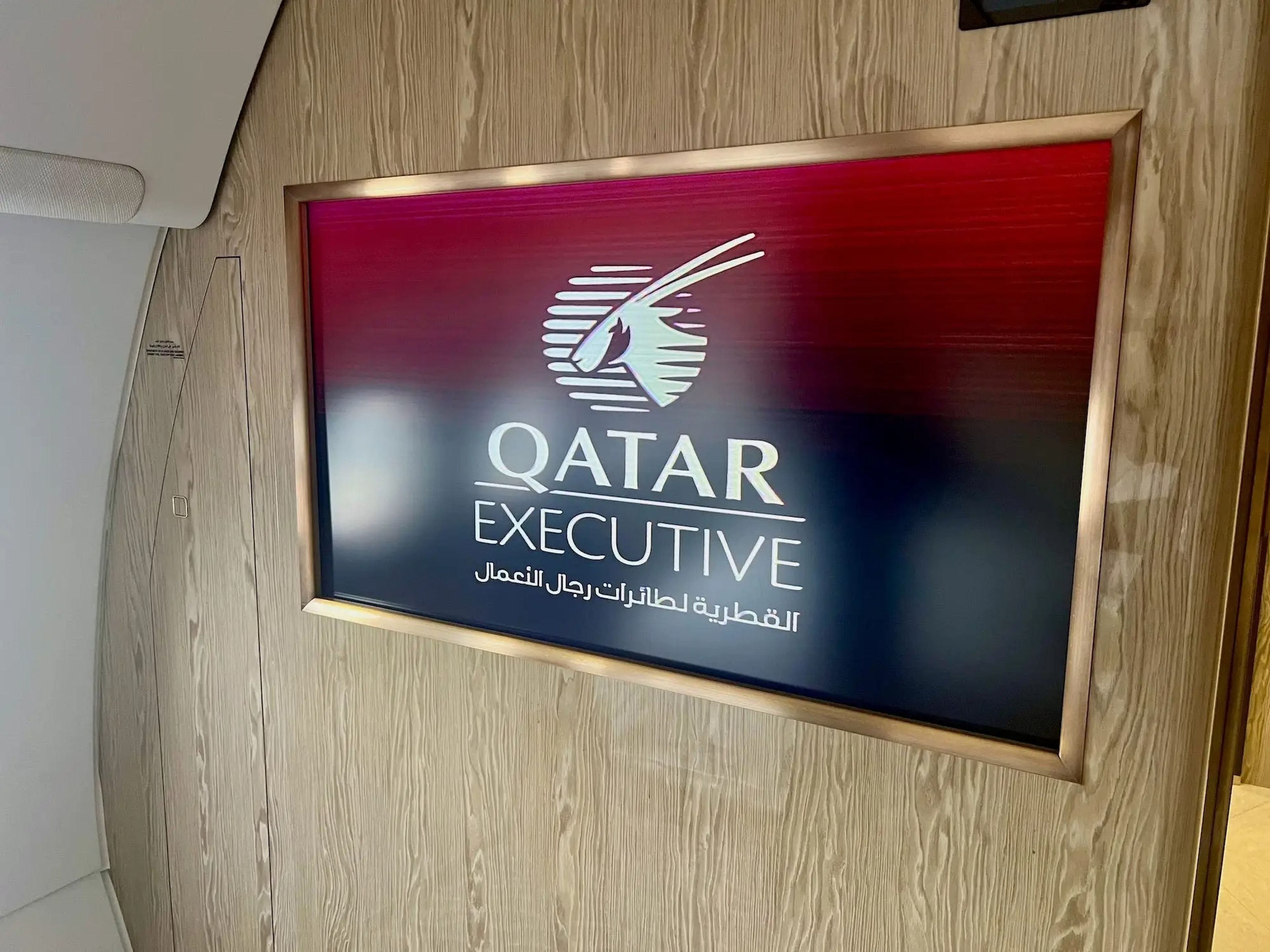 The TV with the Qatar Executive logo and branding displayed on the screen.