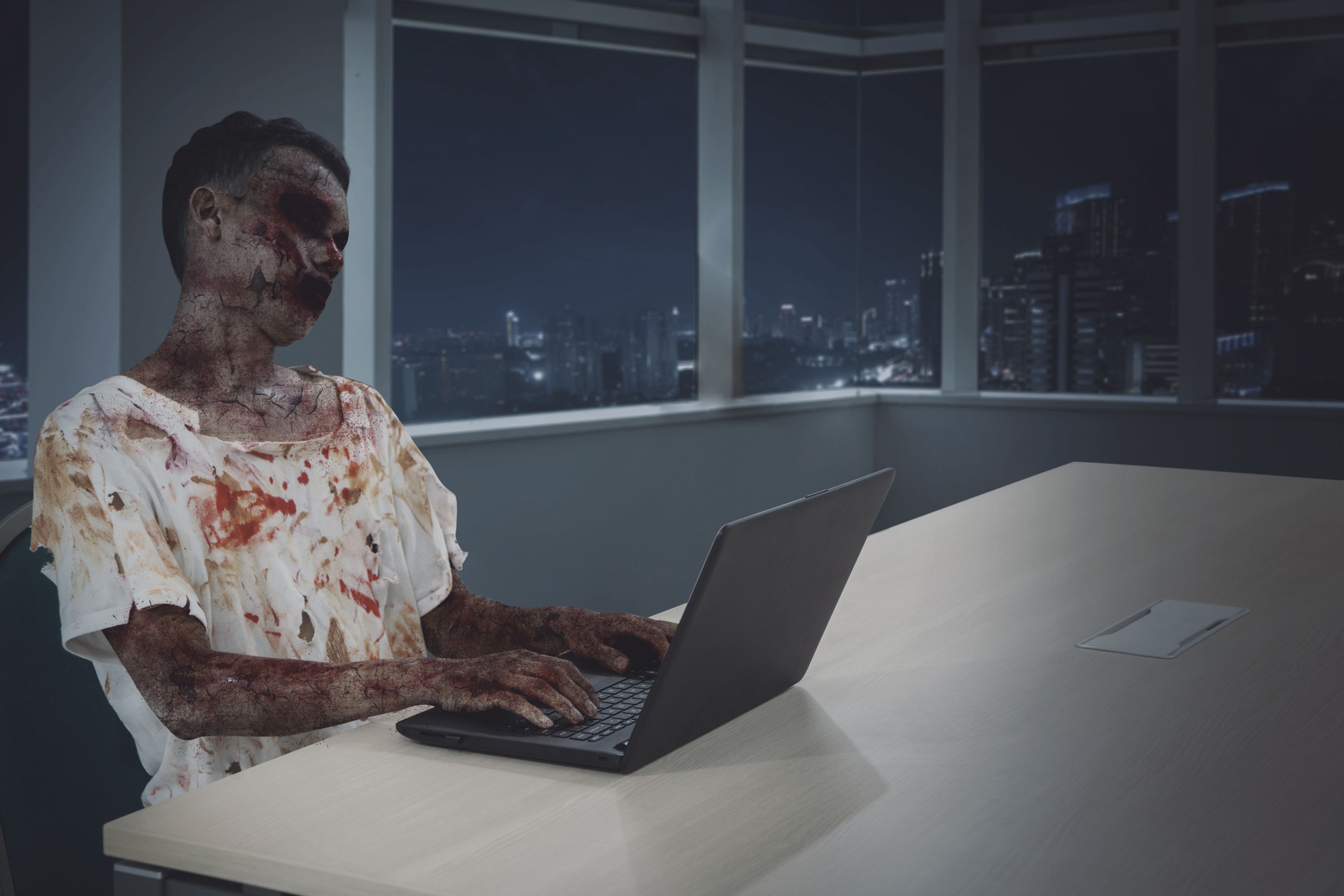 Un zombie trabaja con un ordenador. 