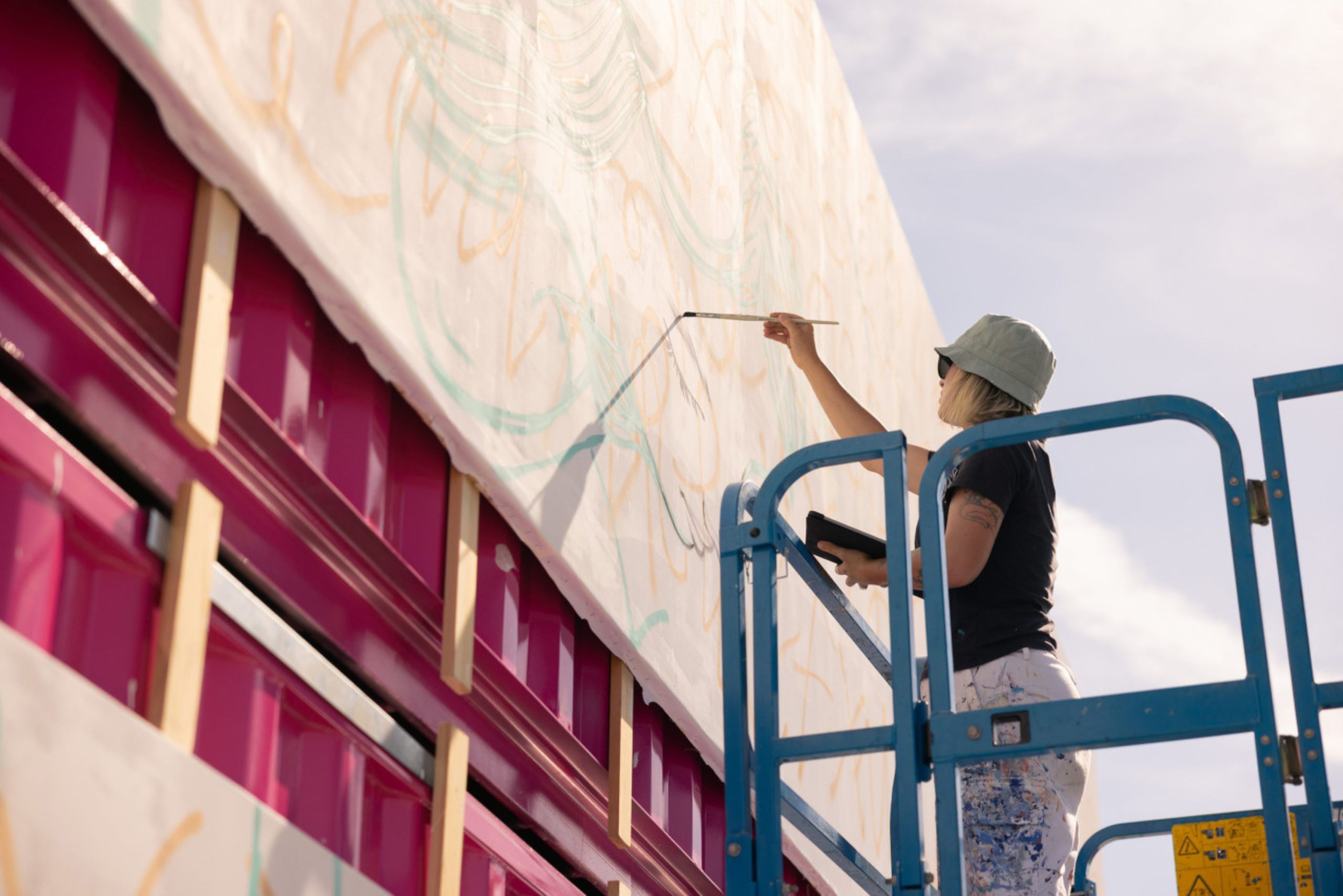 La artista Lidia Cao, en pleno proceso artístico del mural compuesto por 4 contenedores marítimos.