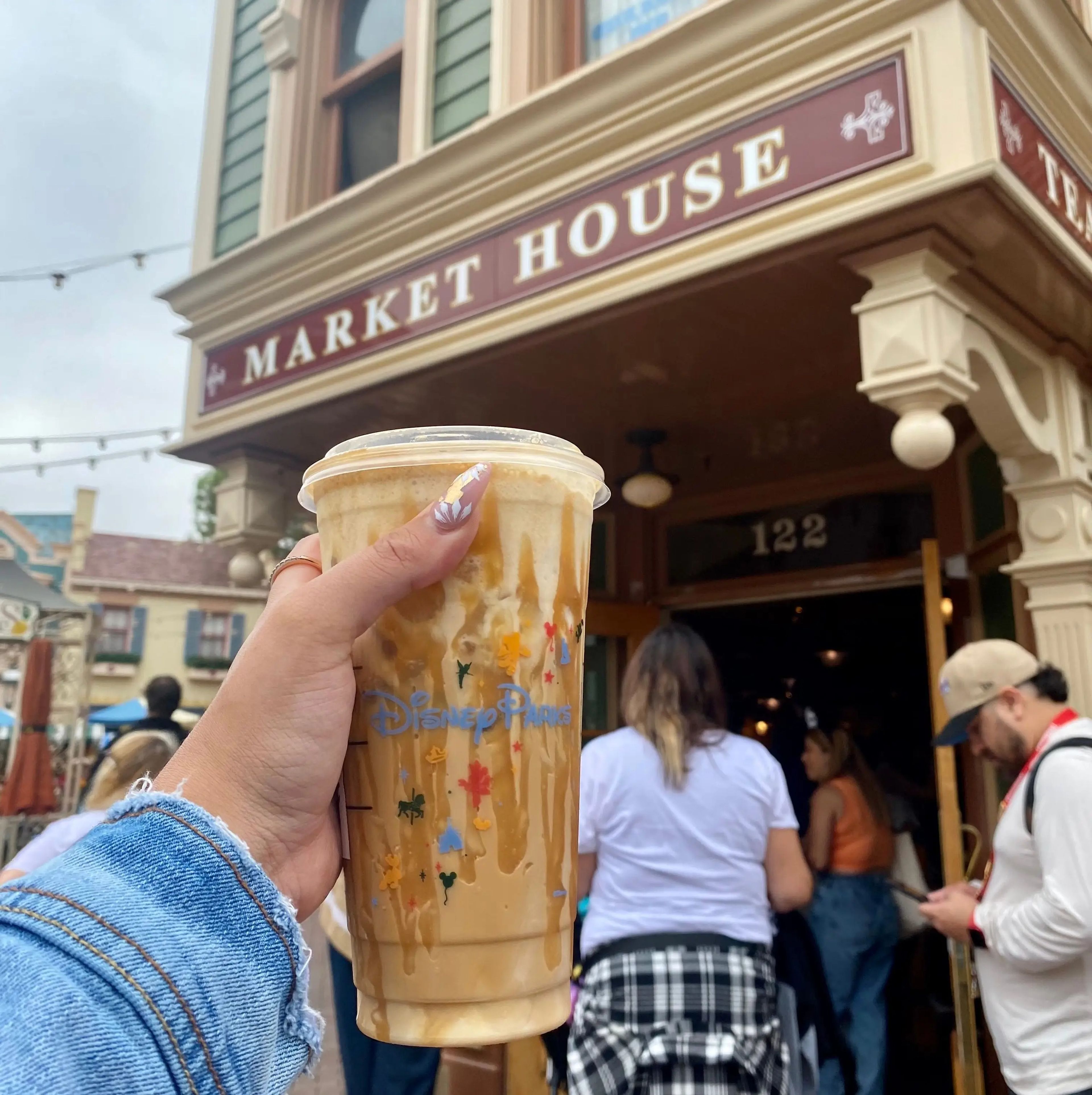 A Disney Parks Starbucks drink in front of the Market House.