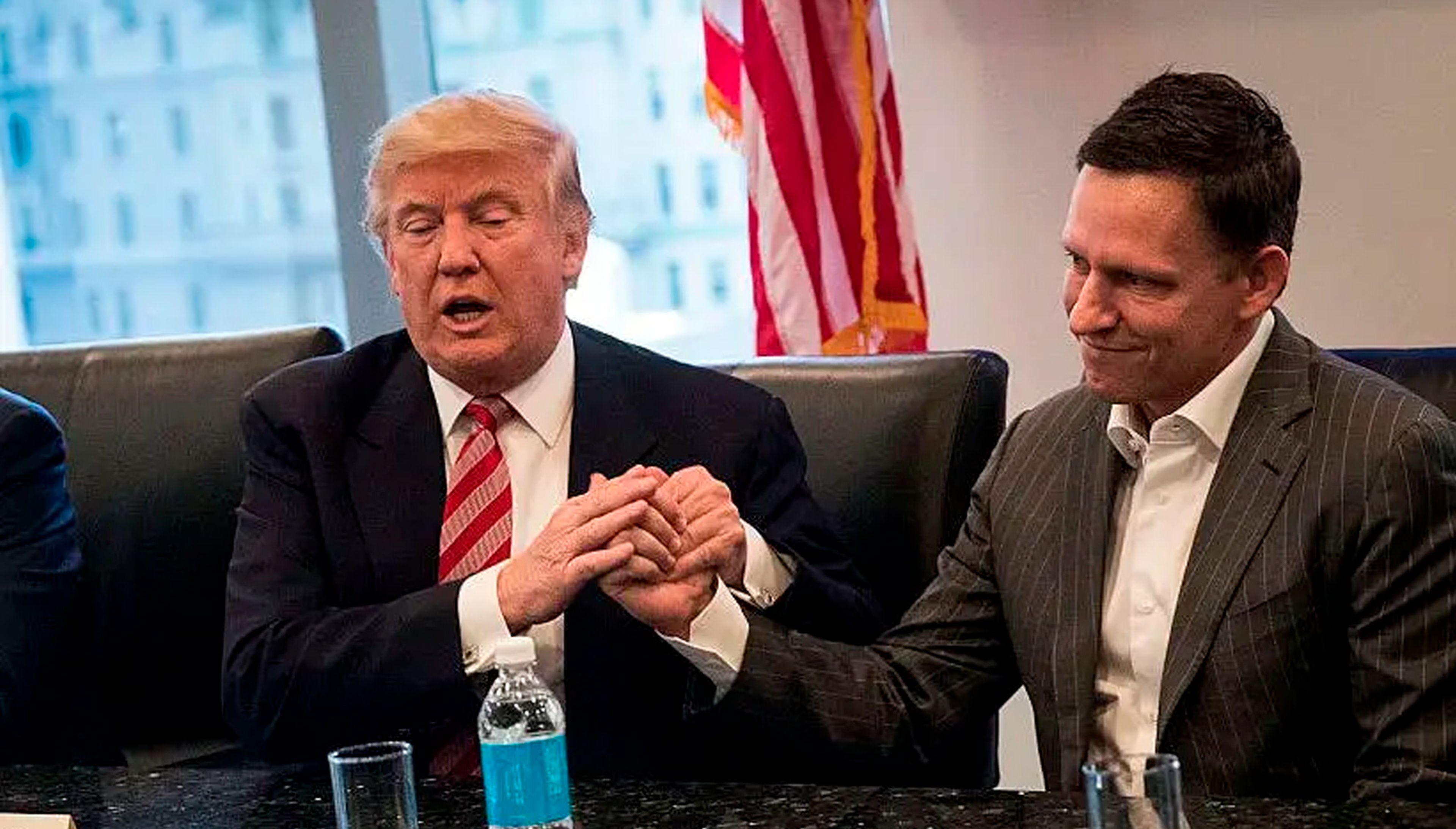 El entonces presidente electo Donald Trump estrecha la mano de Peter Thiel durante una reunión en la Torre Trump en diciembre de 2016. 
