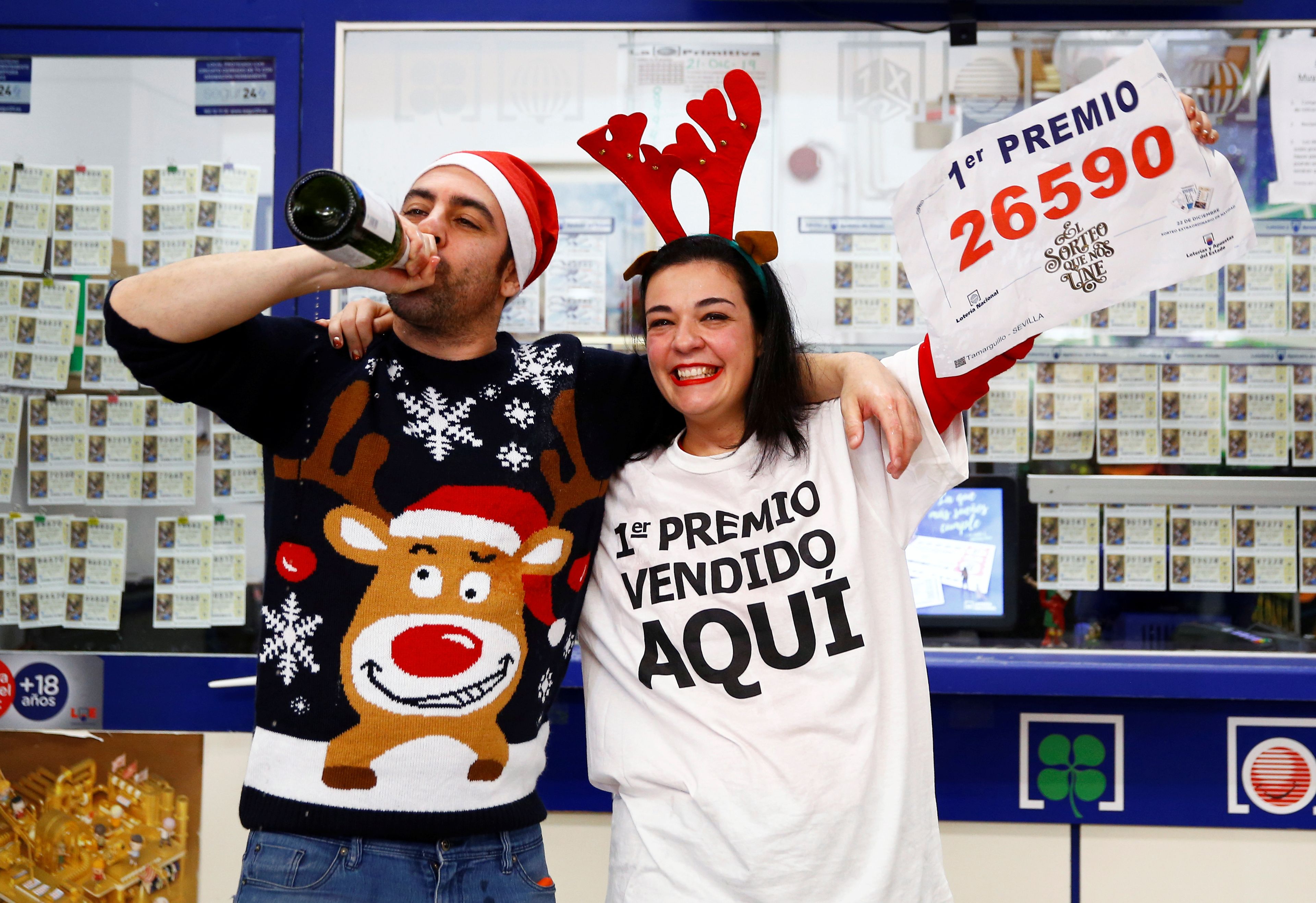 Dos personas celebrando el Gordo de Navidad en administración de lotería