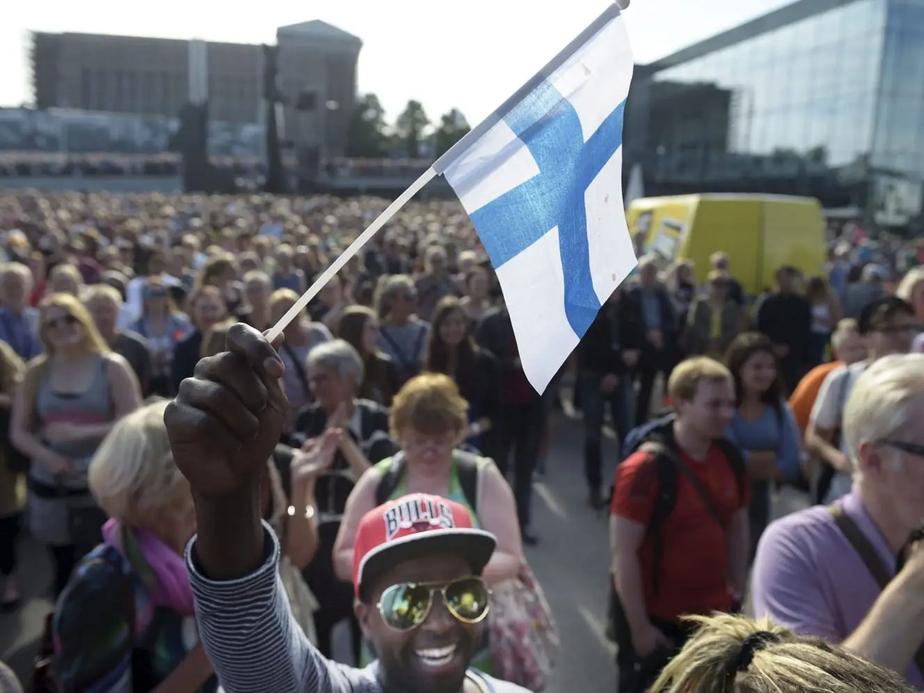 Un hombre sostiene una bandera finlandesa.