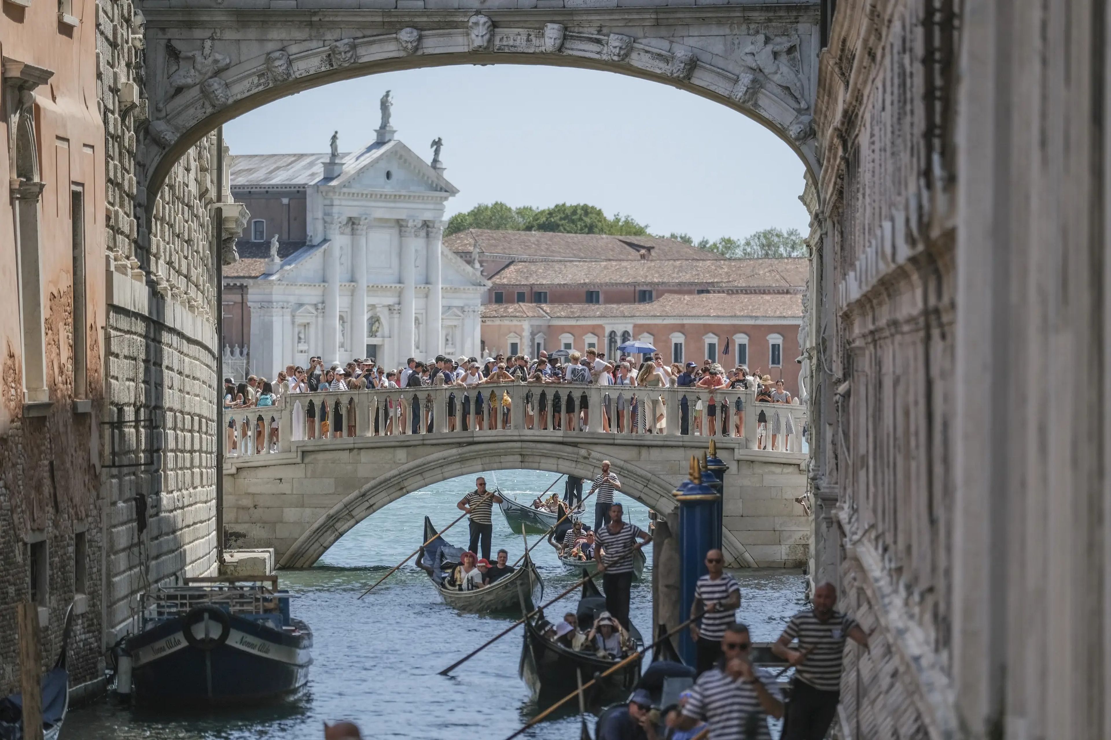 Varias góndolas pasan lentamente bajo el Puente de los Suspiros, cerca de la Plaza de San Marcos, debido al exceso de tráfico, el 2 de agosto de 2023 en Venecia, Italia.