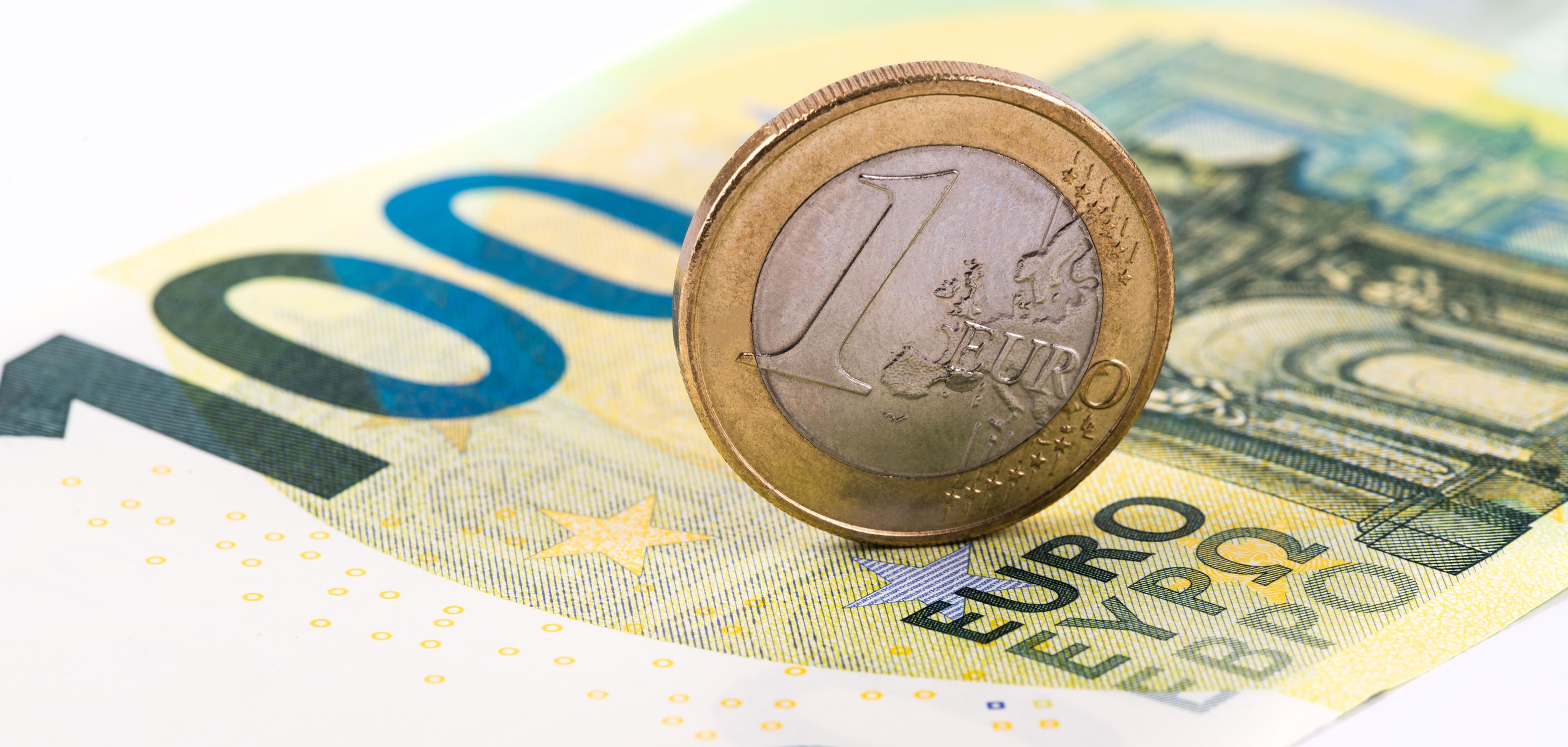Moneda de un euro sobre un billete de cien euros