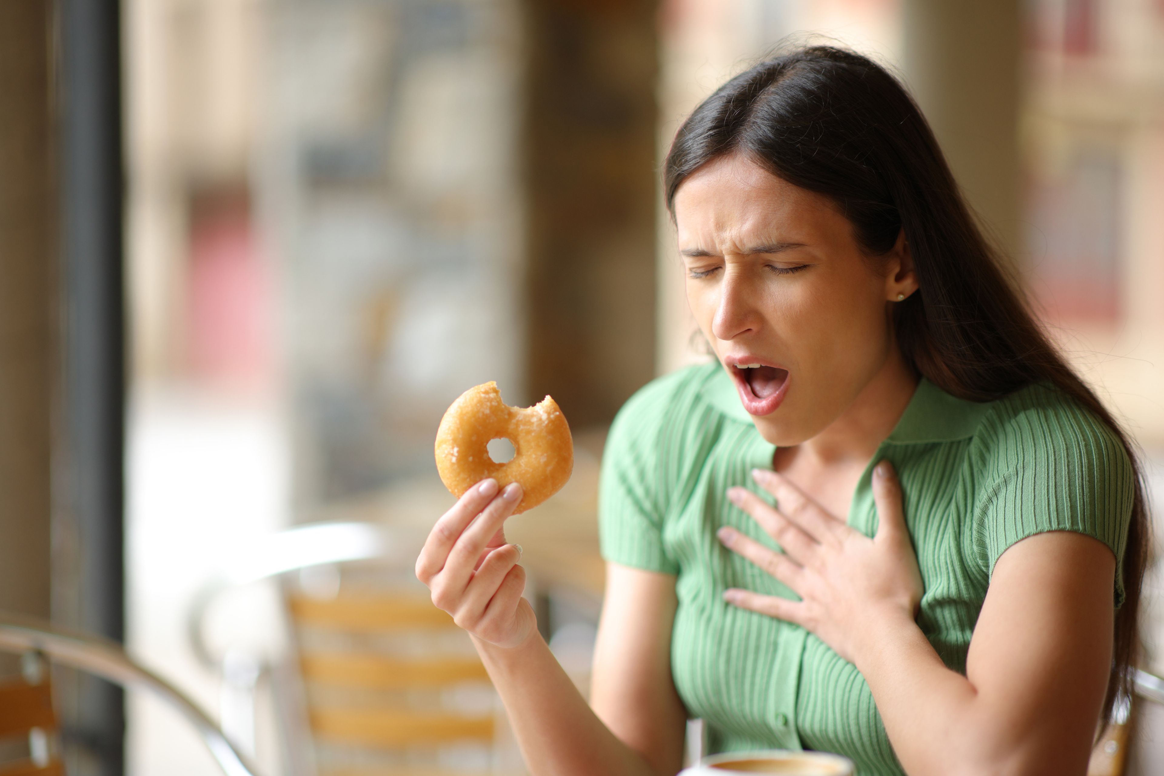 Mujer teniendo una reacción alérgica mientras come