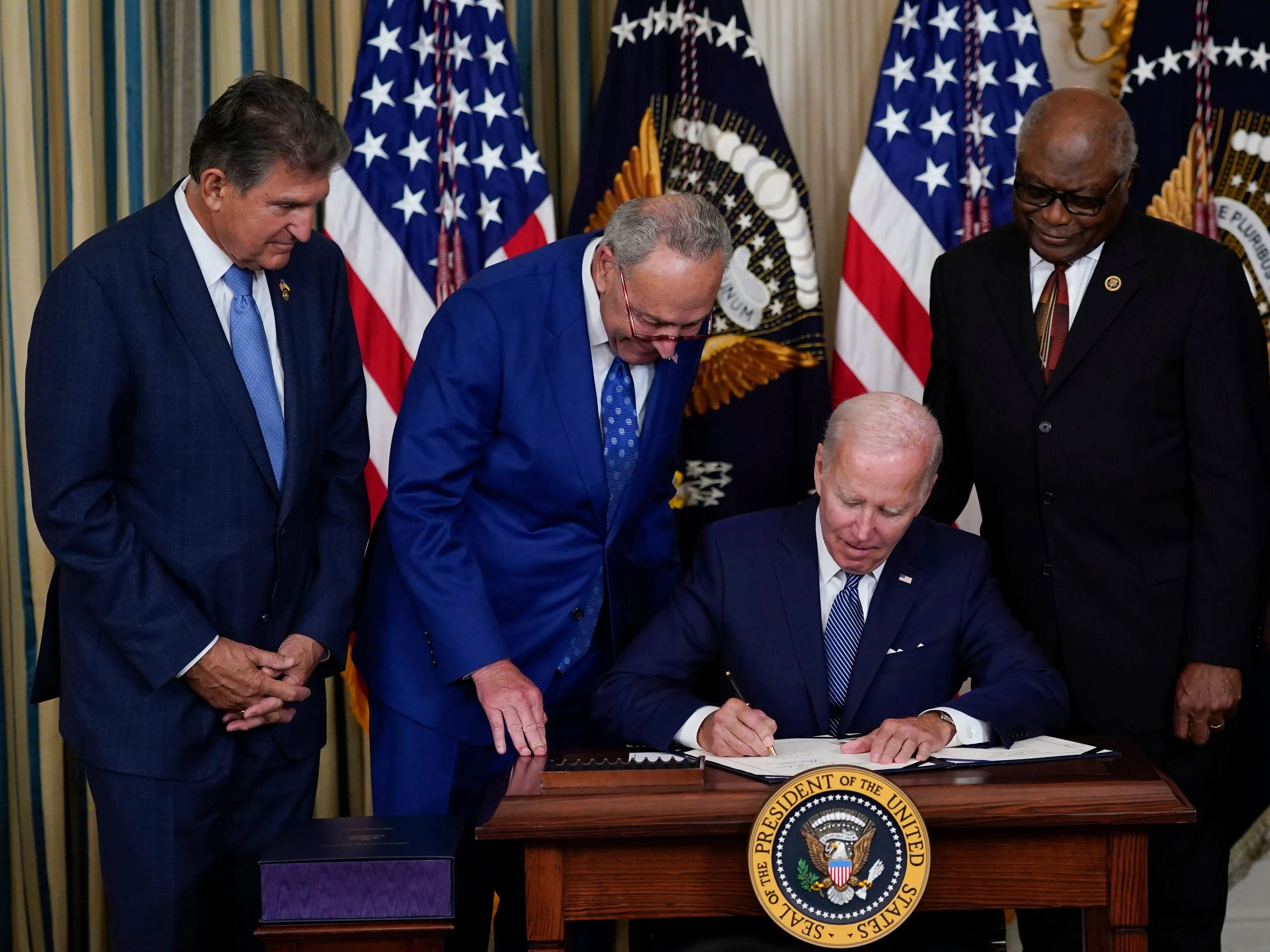 El presidente Joe Biden, en el centro, firma la Ley de Reducción de la Inflación en el Comedor de Estado de la Casa Blanca el 16 de agosto de 2022.