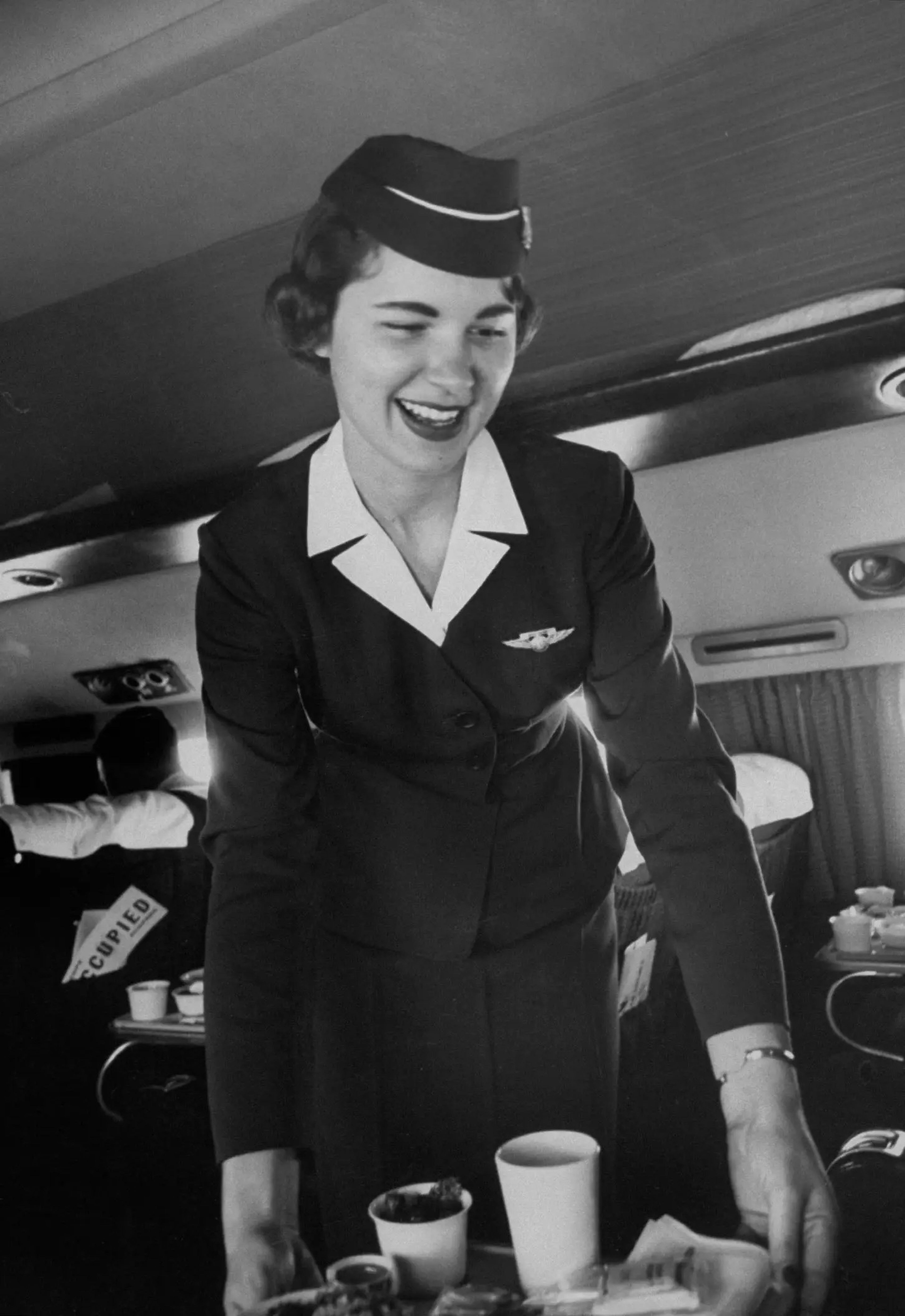 Una foto de 1958 muestra a una azafata de American Airlines sirviendo comida.