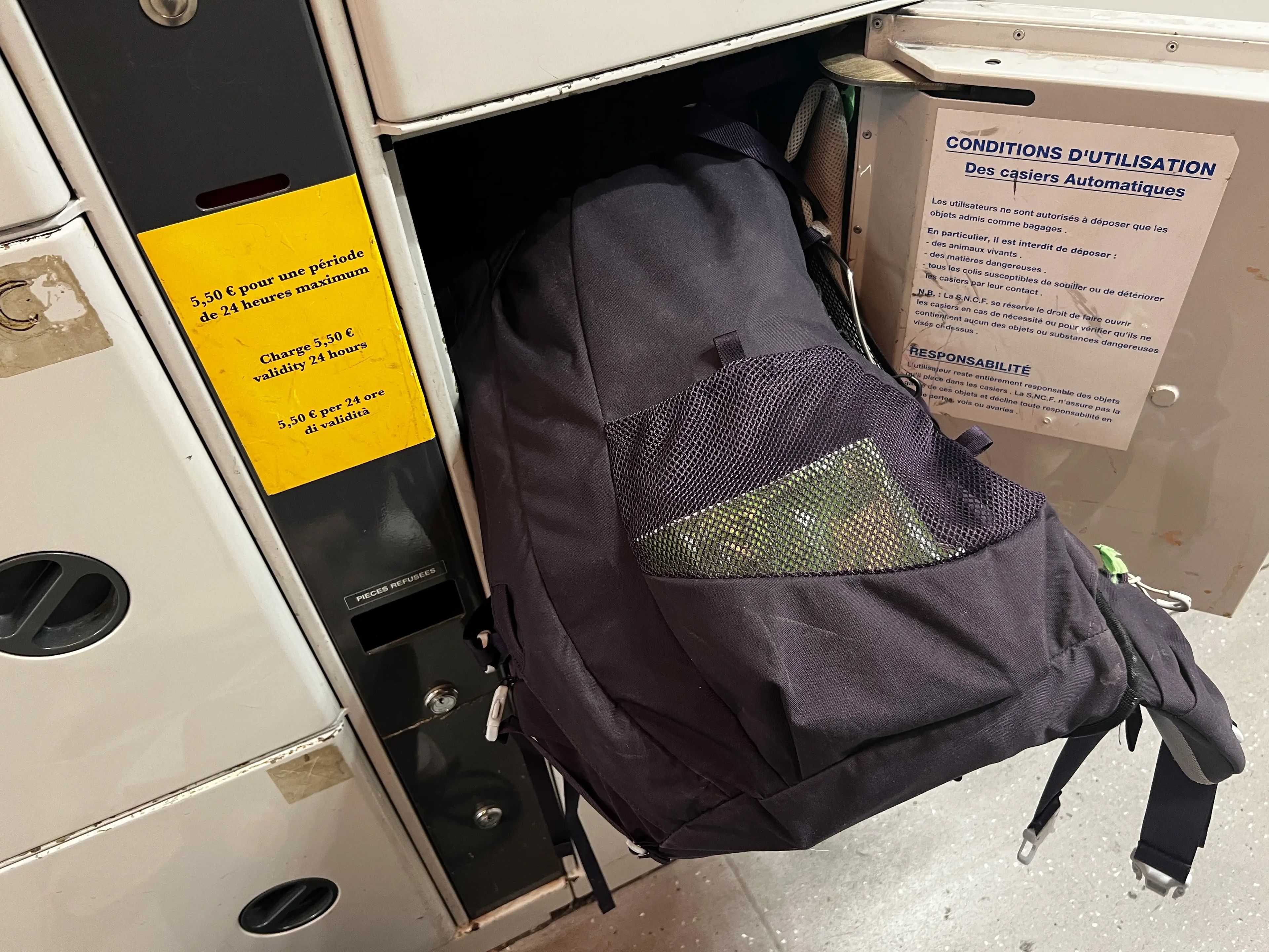 A backpack being put in a train locker.