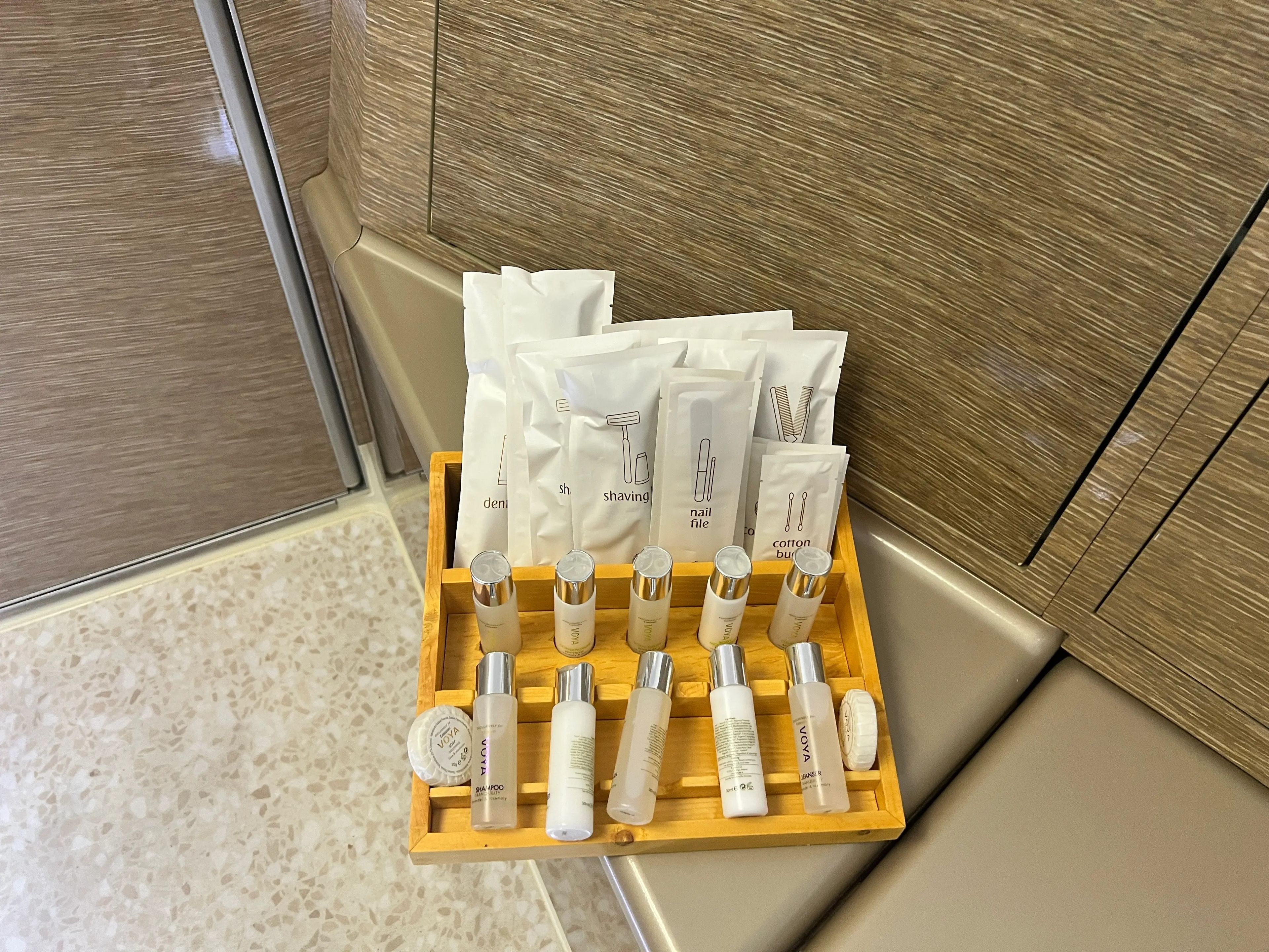 A close up of the hygiene amenities in white packages and bottles in A380 Emirates first class,