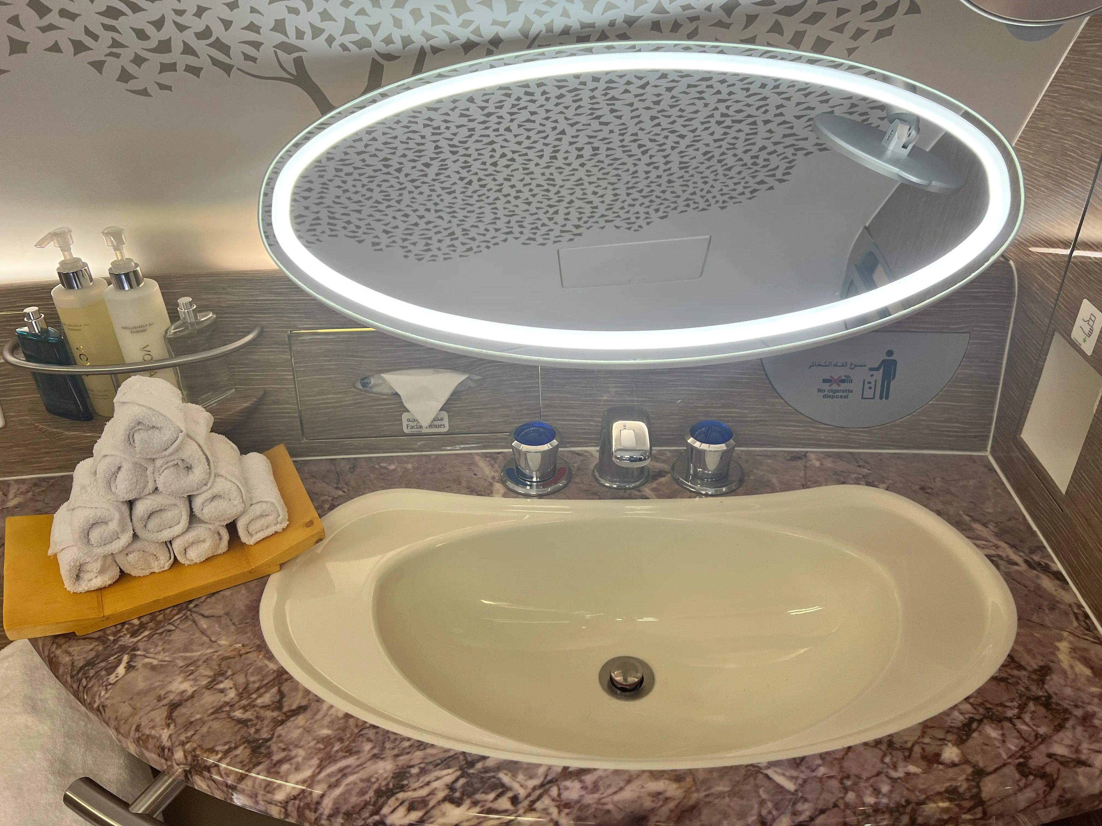 A close-up of the sink and mirror, with soaps and towels beside, in Emirates A380 shower spa